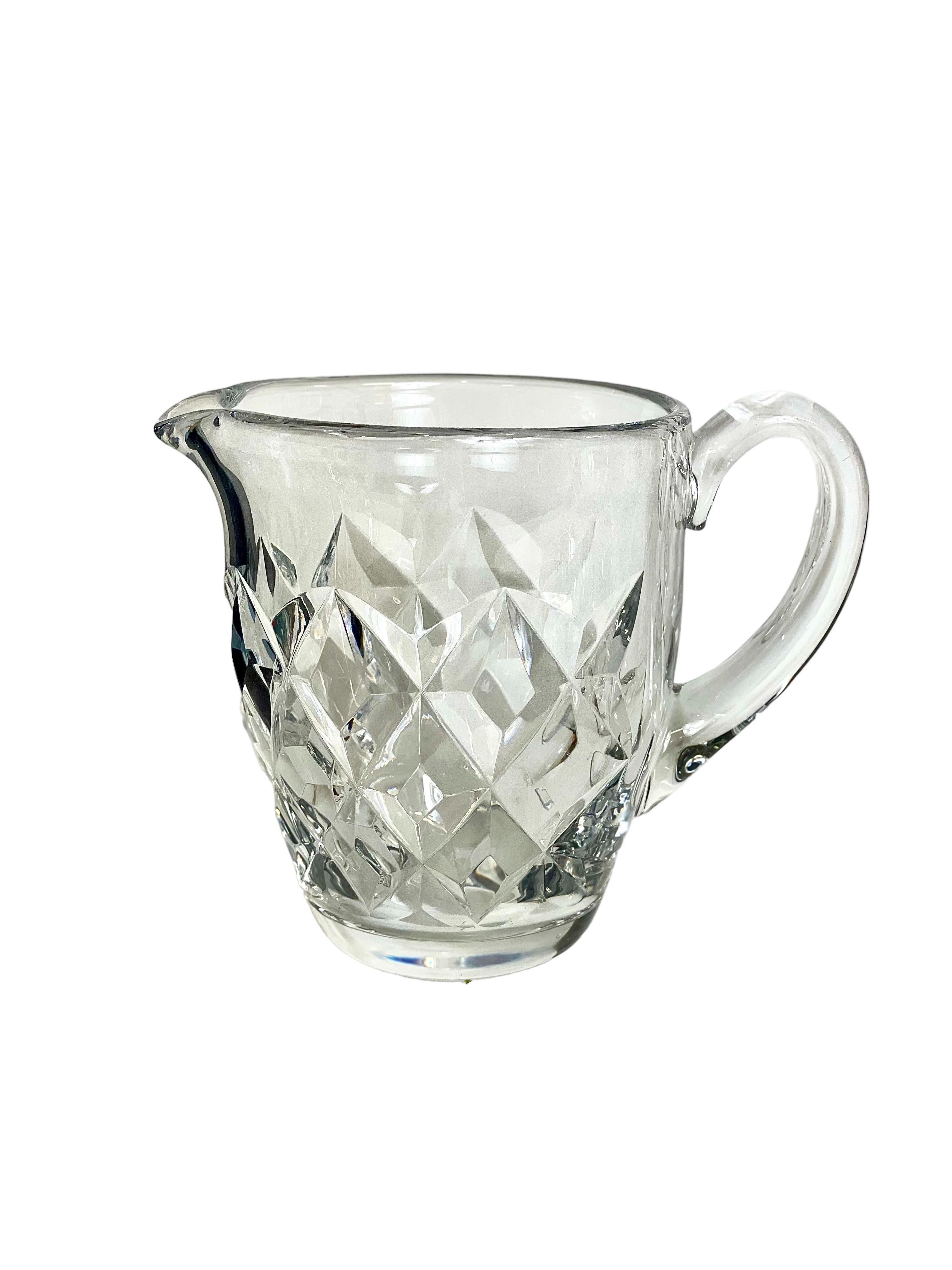 A sparklingly clear Saint Louis crystal water jug, or pitcher, from the 'Adour' pattern series, dating from around 1950. This timeless design, with its network of cross-cut diamonds, was first listed in the company's 1948 catalogue. Its ergonomic