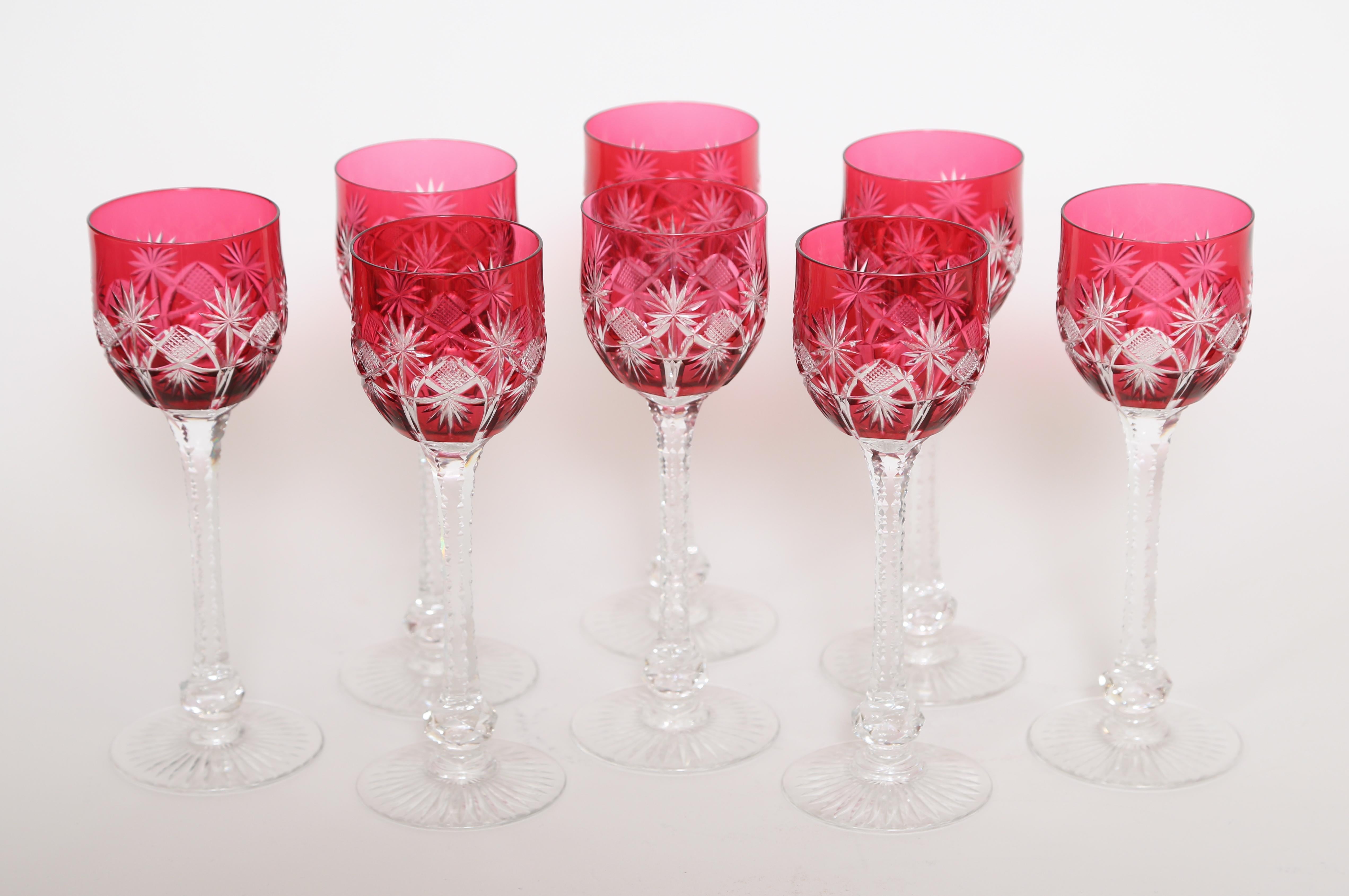 Set of eight Saint Louis cut crystal wine glasses. These hand blown stems were cased with cranberry glass and then cut back to clear.  The foot of each stem is star cut while the bowls are exquisitely cut.  They remain in excellent condition with no