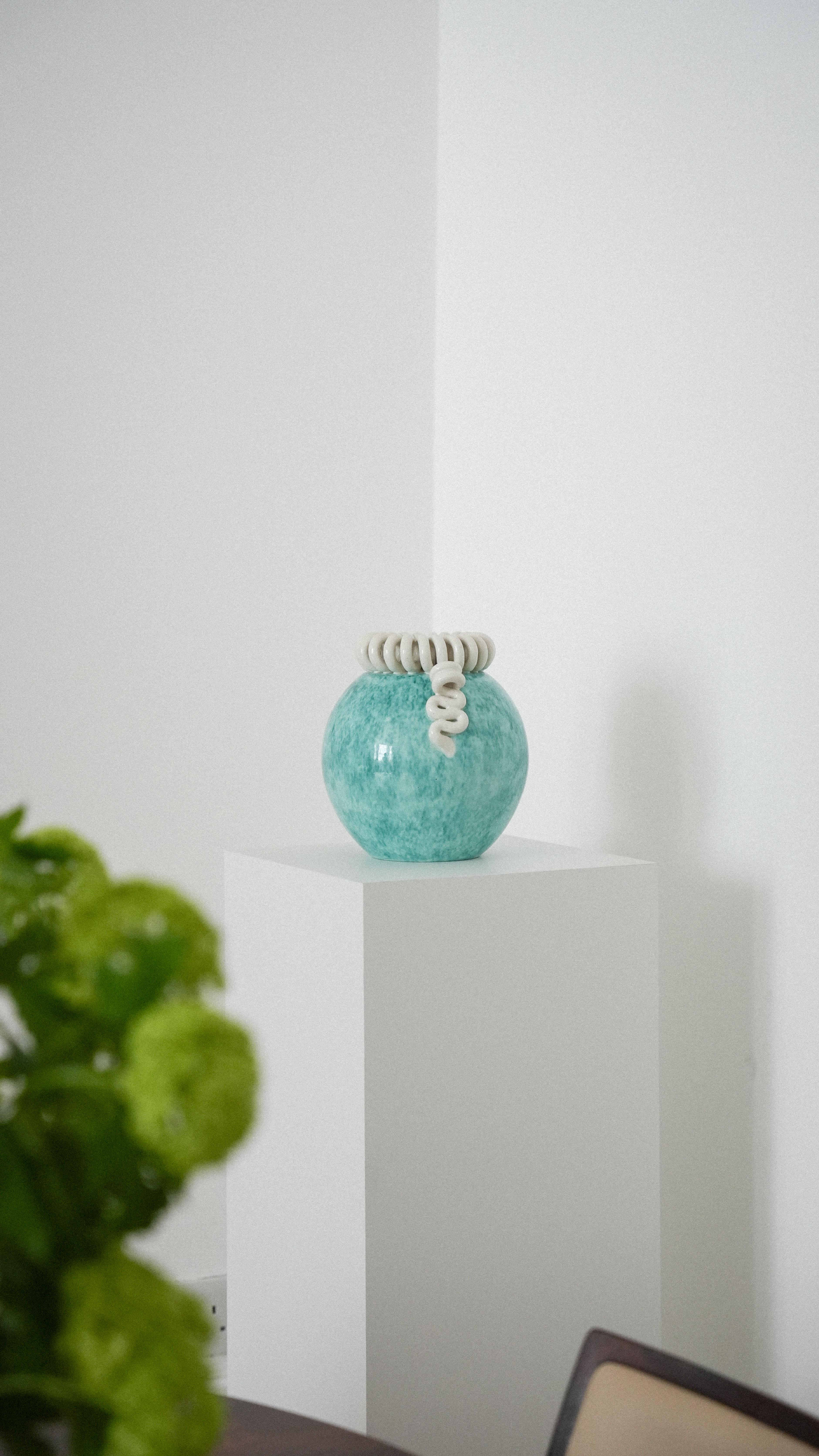 Skurrile Boule-Vase aus gesprenkeltem türkisfarbenem Steingut mit cremefarbenen Bandlocken aus Fayence de Sainte Radegonde, Frankreich, um 1920.

Diese Vase mit Tonschleifen stammt aus den Fayencen von Sainte Radegonde, Frankreich, das für die