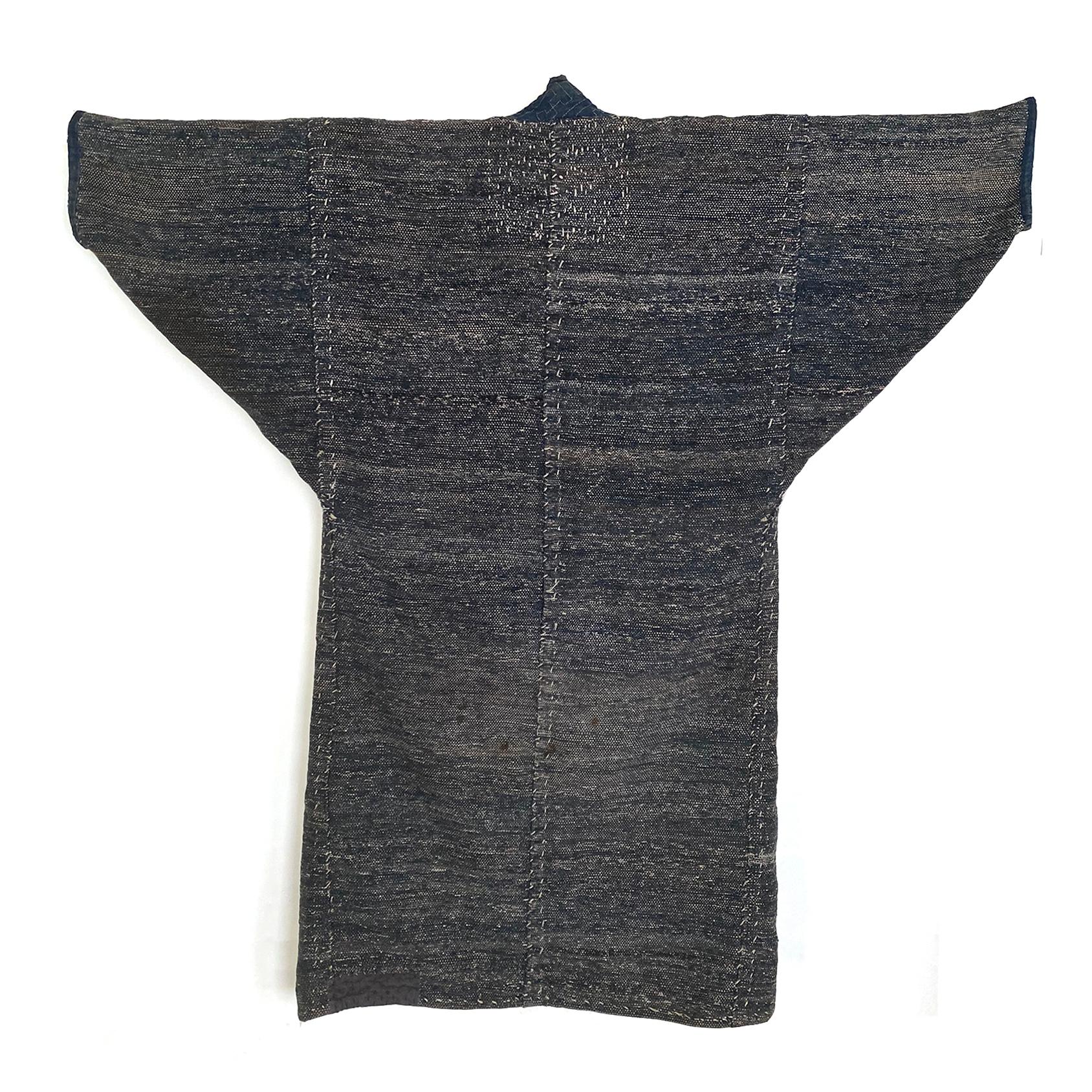 Saki-ori farmers coat, Northern Japan, Meiji period

A very heavy and substantial saki-ori coat, made of cotton with an indigo kasuri lapel. Several patches of hand sewn stitching to reinforce or repair various areas.
     