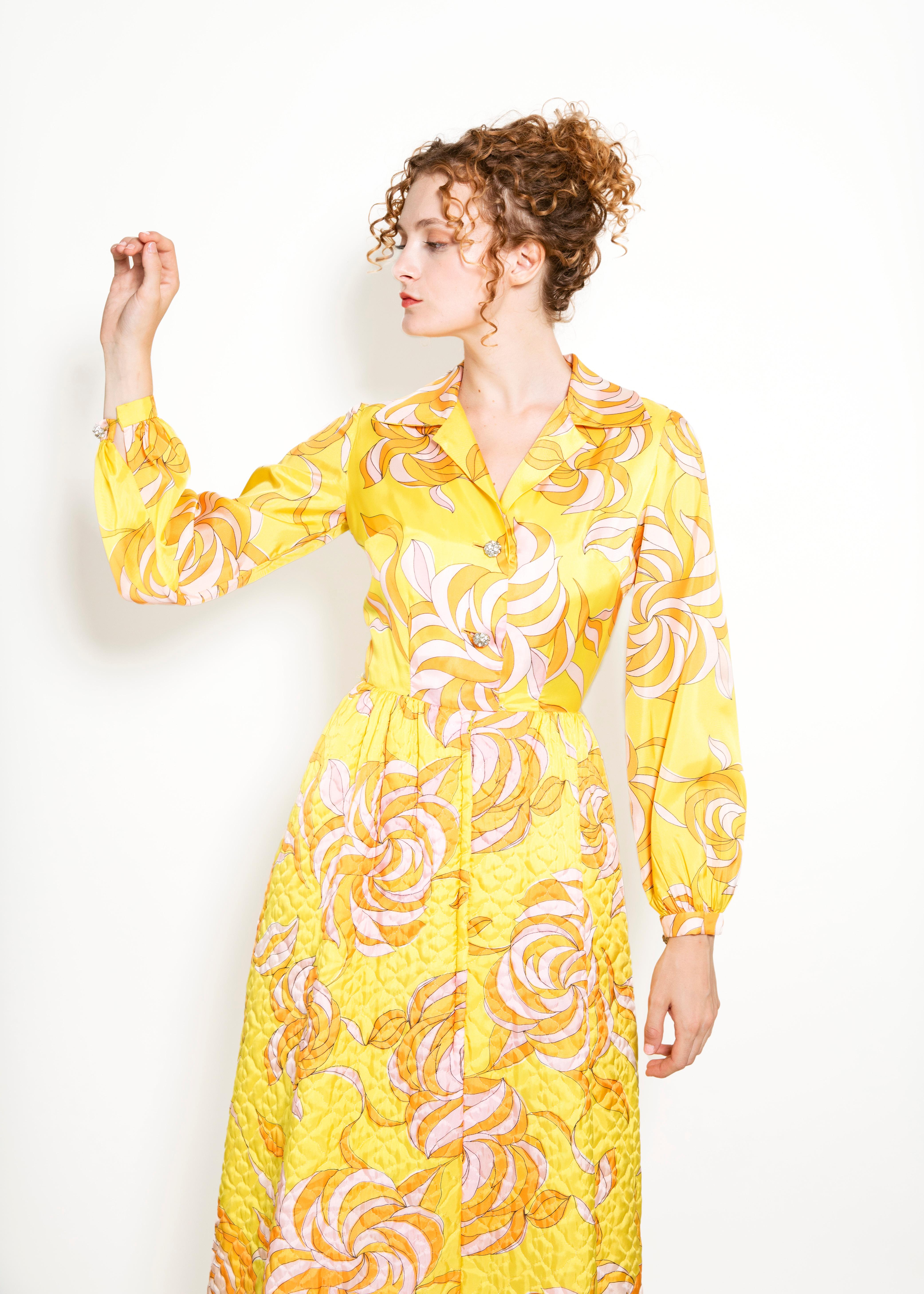 Make an impressive entrance with this vintage Saks Fifth Ave dress! Featuring a unique quilted pattern, shimmery rhinestone buttons, and a vibrant yellow-orange-pink floral print, it's like stepping out of a time machine in the most fashionable way