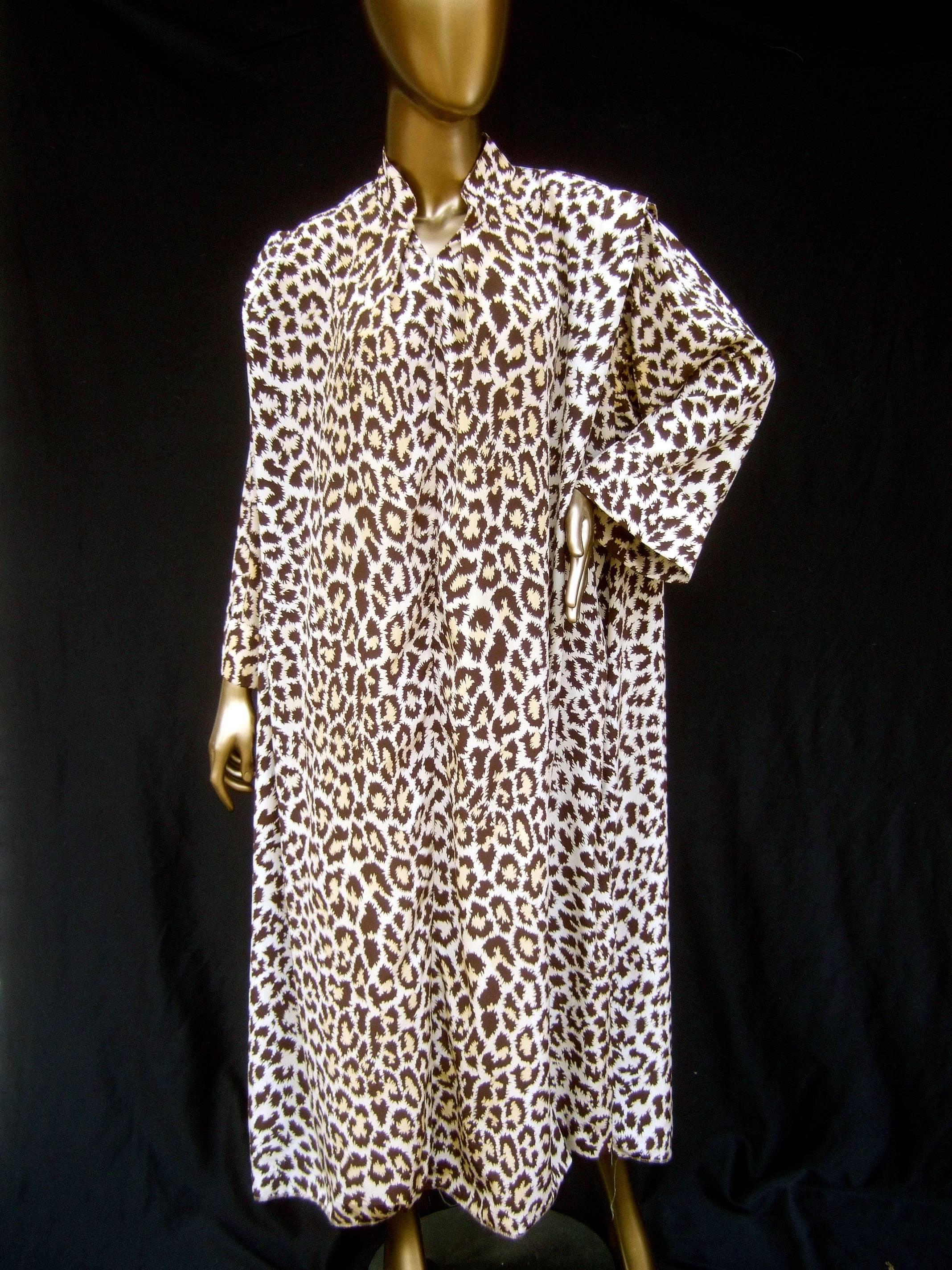 Saks Fifth Avenue Exotic animal print lounge gown for Mollie Parnis c 1970s
The stylish loose polyester animal print lounge gown is light and breezy 
The loose silhouette crosses over several sizes 

Partially zippers down the front neckline. The