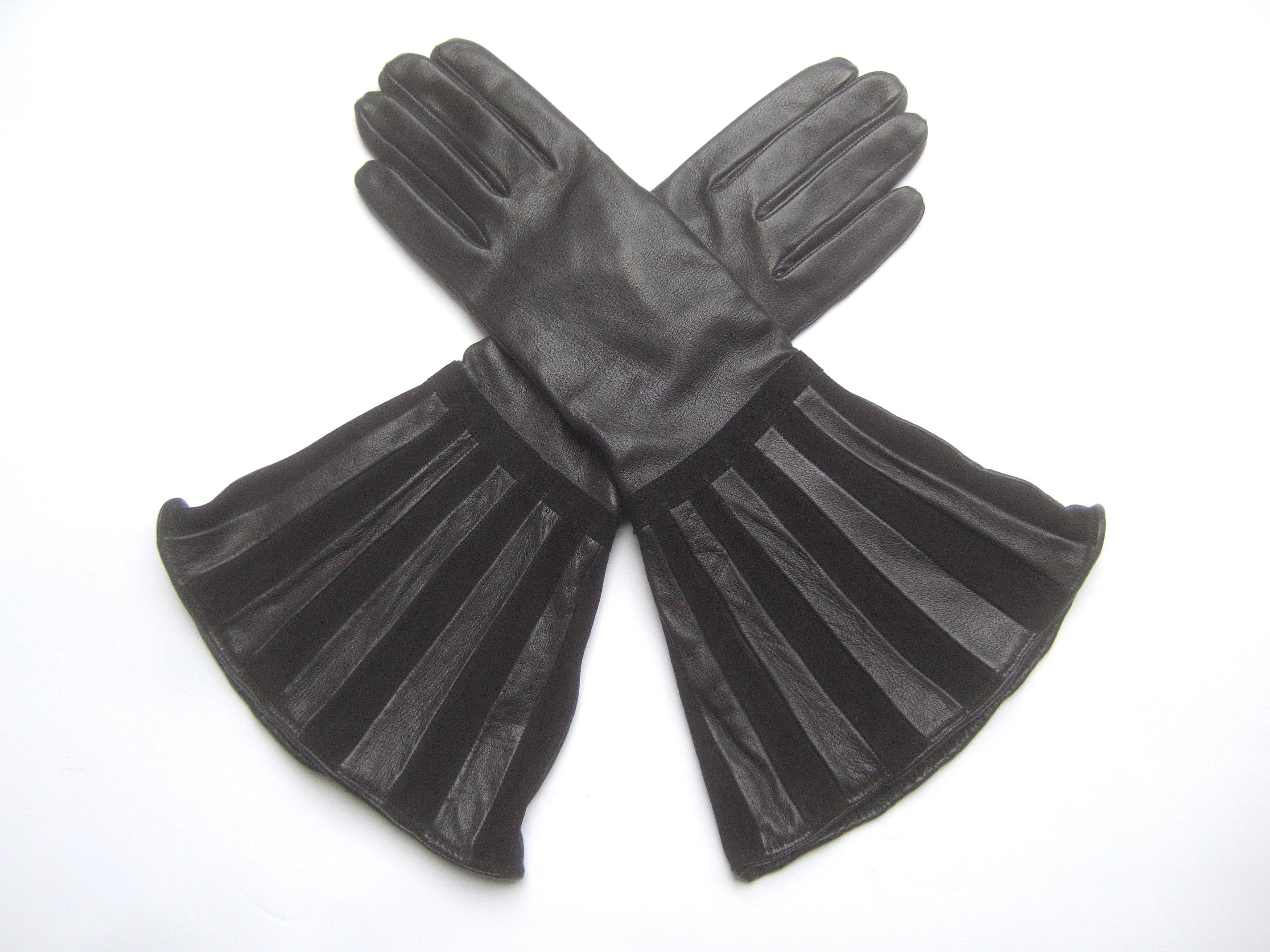 Saks Fifth Avenue Avant-garde black leather & suede trim gloves c 1980s 
The chic gloves are constructed with smooth buttery soft leather. The wide flared openings are designed with striped bands that alternate from smooth black leather to plush