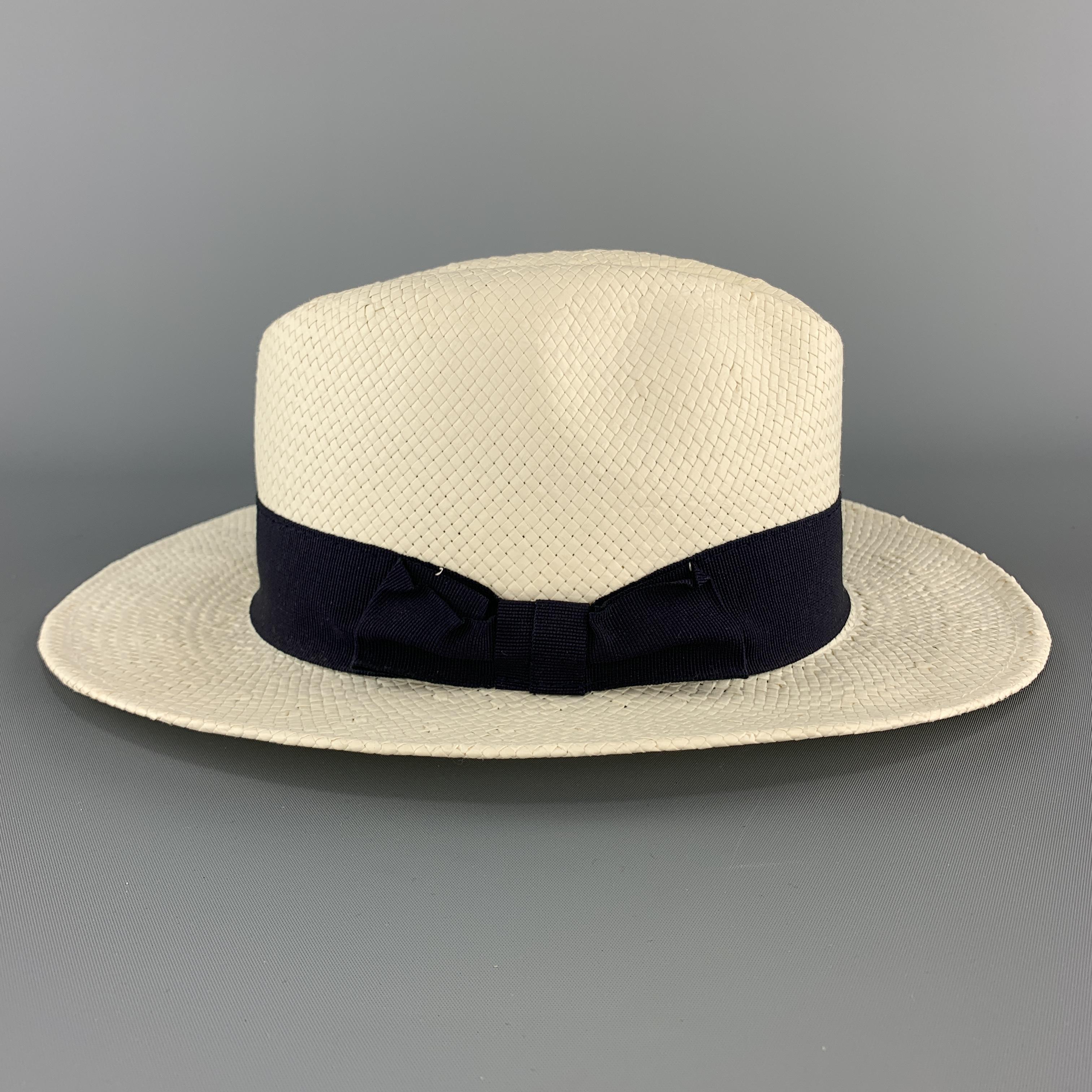 SAKS FIFTH AVENUE fedora comes in cream woven straw with a navy blue ribbon stripe. Made in Italy.

Excellent Pre-Owned Condition.
Marked: (no size)

Measurements:

Opening: 23 in.
Brim: 2.25 in.
Height: 4.5 in.