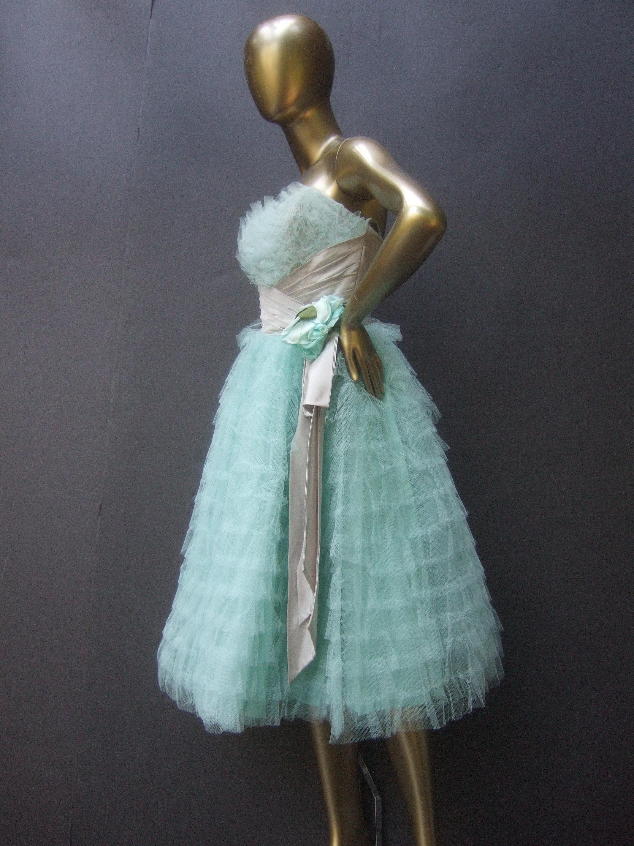 Saks Fifth Avenue Frothy robin's egg pale blue tulle dress c 1950s
The retro blast from the past tulle dress is designed with a pewter-tone ruched pleated satin stationary sash band that runs under the bodice and extends to the backside & drapes off