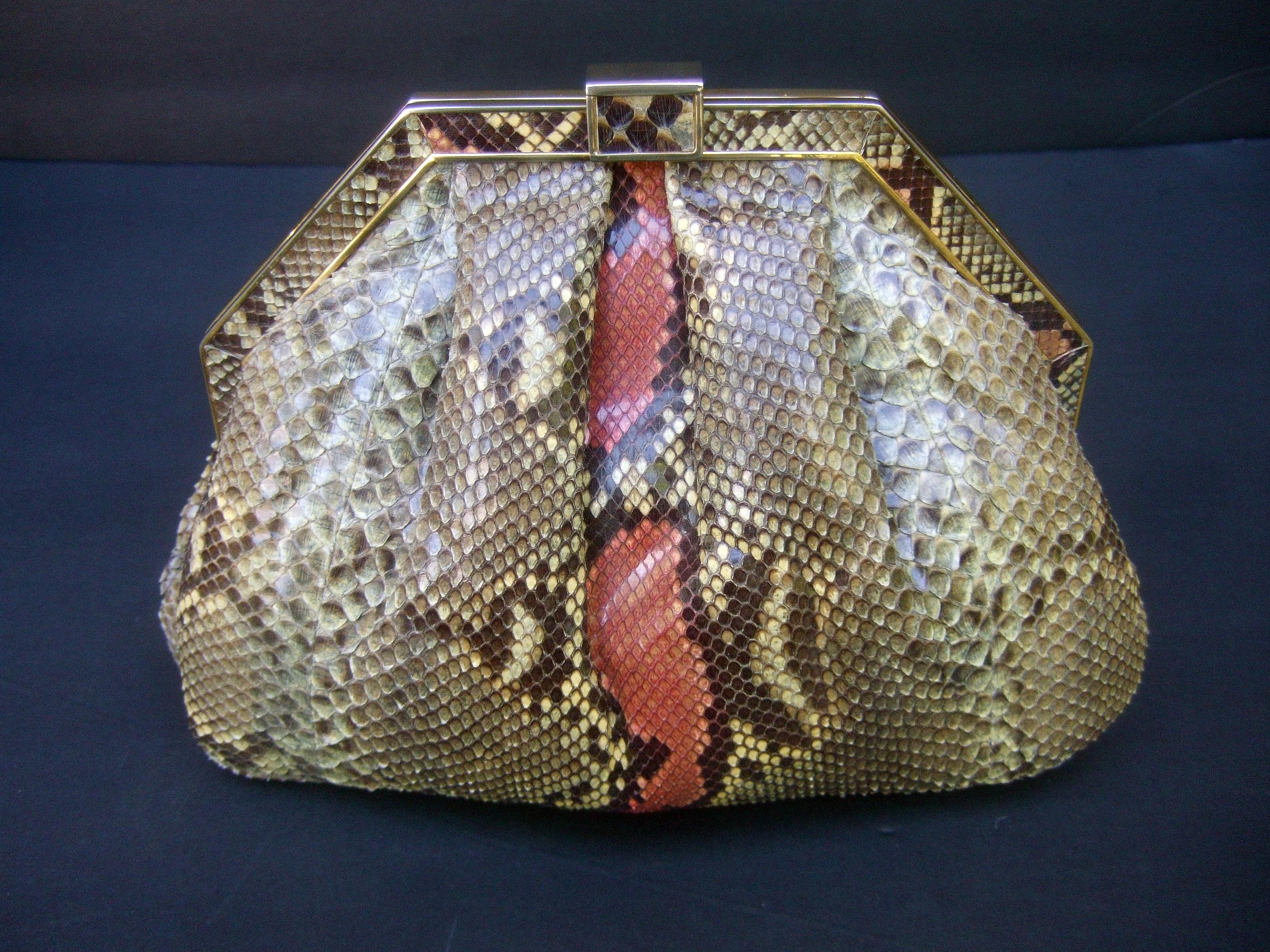 Saks Fifth Avenue Sleek Italian python handbag c 1980s
The versatile handbag transitions from a chic clutch
Converts to a stylish shoulder bag carried with the
gilt metal shoulder strap chain

The exterior is covered with exotic snakeskin with