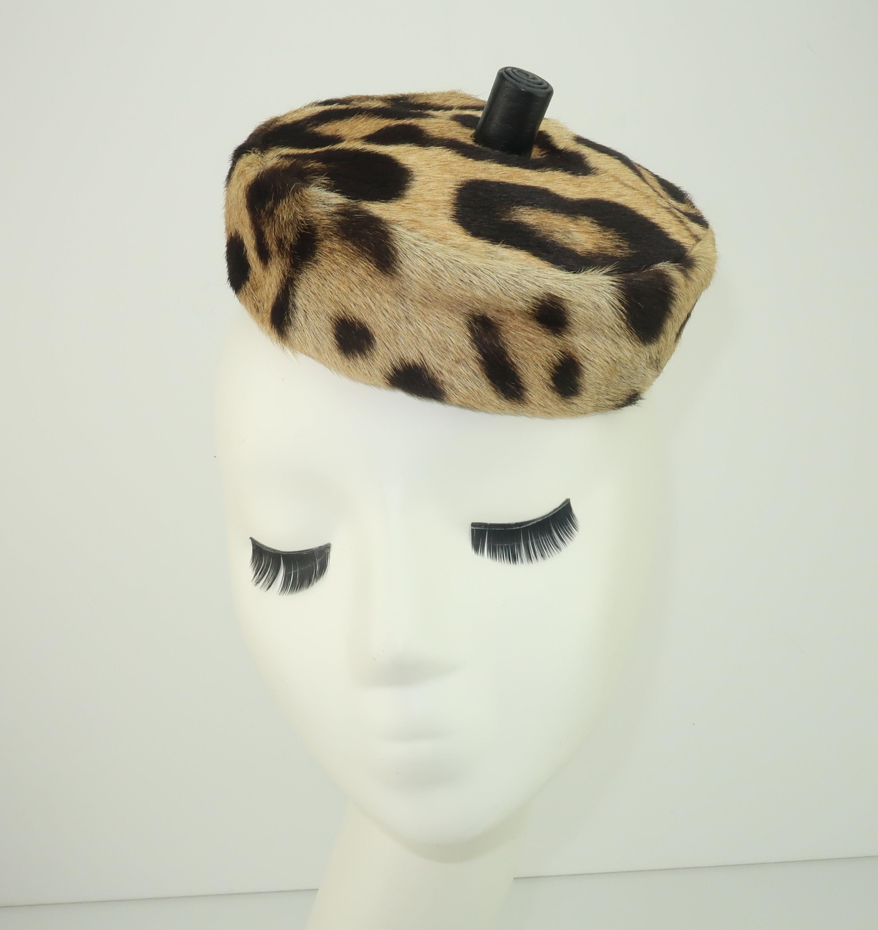 Add a chic exotic flavor to your wardrobe with this fashionable leopard print fur pillbox hat with a black leather finial from Saks Fifth Avenue.  This minimalist shape can be worn forward, back or cocked to one side like a tilt hat.  Lined with