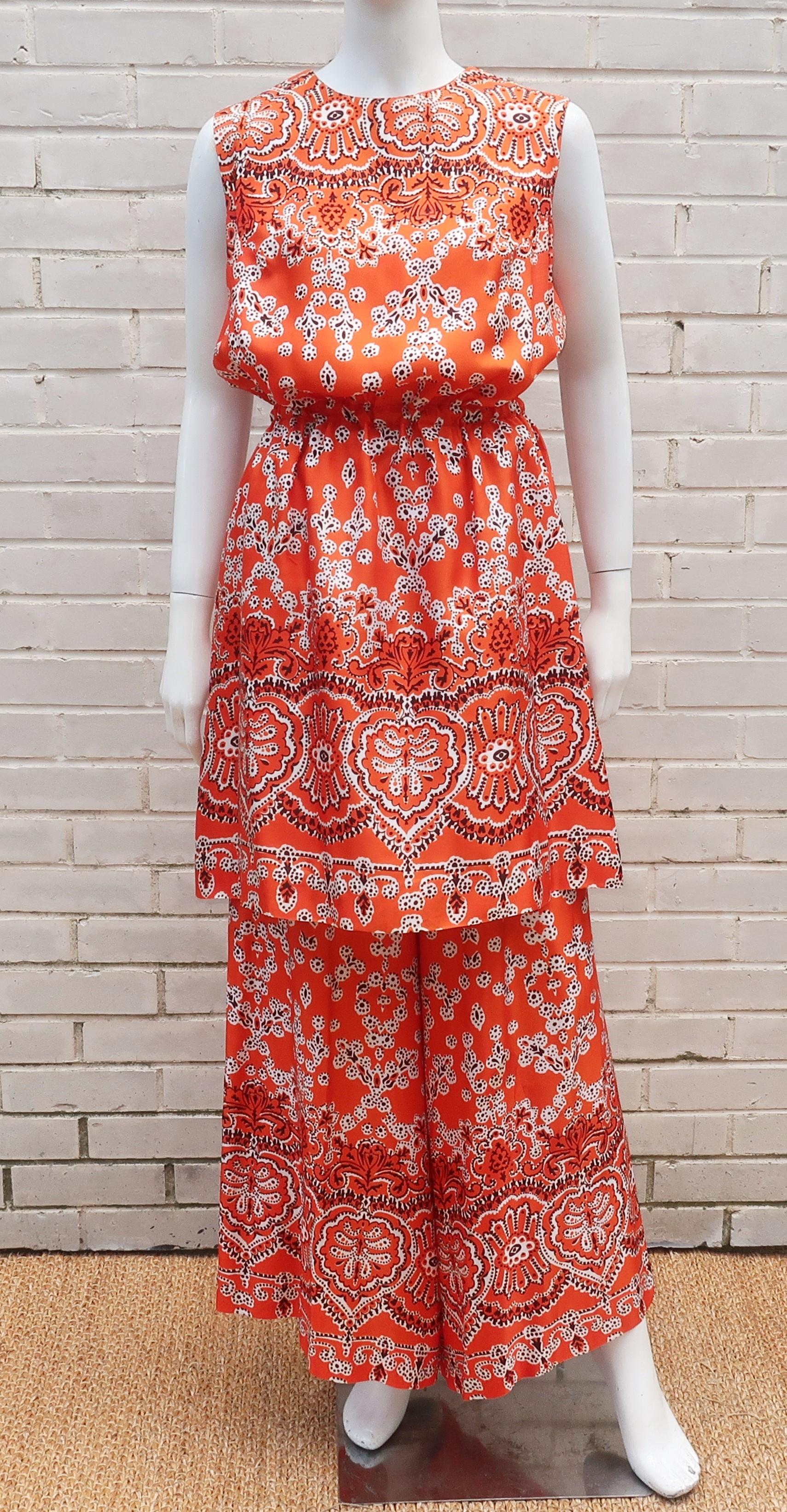 C.1970 Saks Fifth Avenue two piece pant suit in an orange red mod print with black and white highlights.  The two pieces consist of a tunic style top that can also be worn as a dress and pull-on palazzo pants.  Though there is no contents label, the