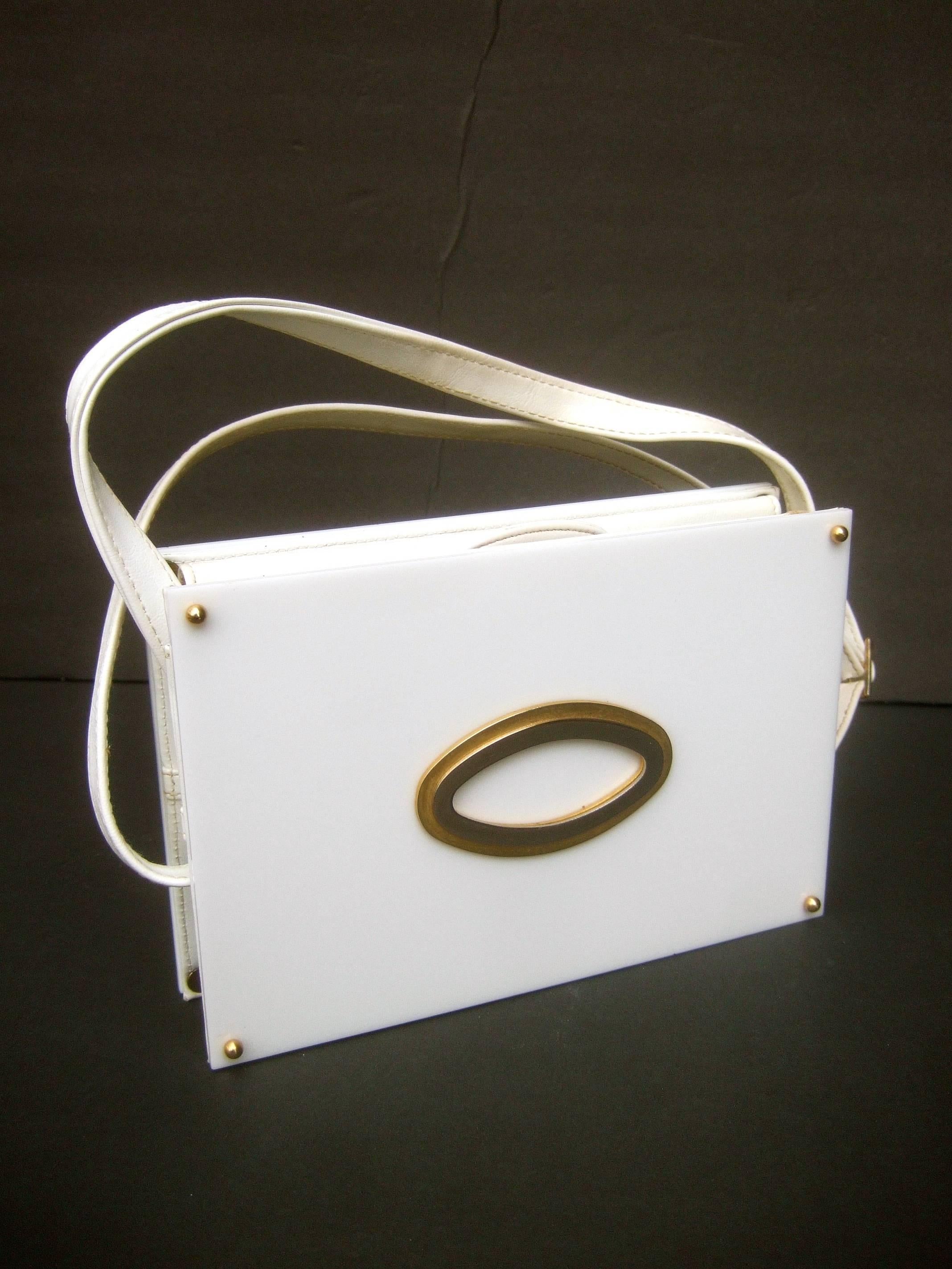 Saks Fifth Avenue mod white lucite tile handbag c 1970s
The sleek retro handbag is designed with a pair 
of white lucite rectangular panels on both the 
front and back exterior sides

The front exterior panel is designed with a pair
of elongated
