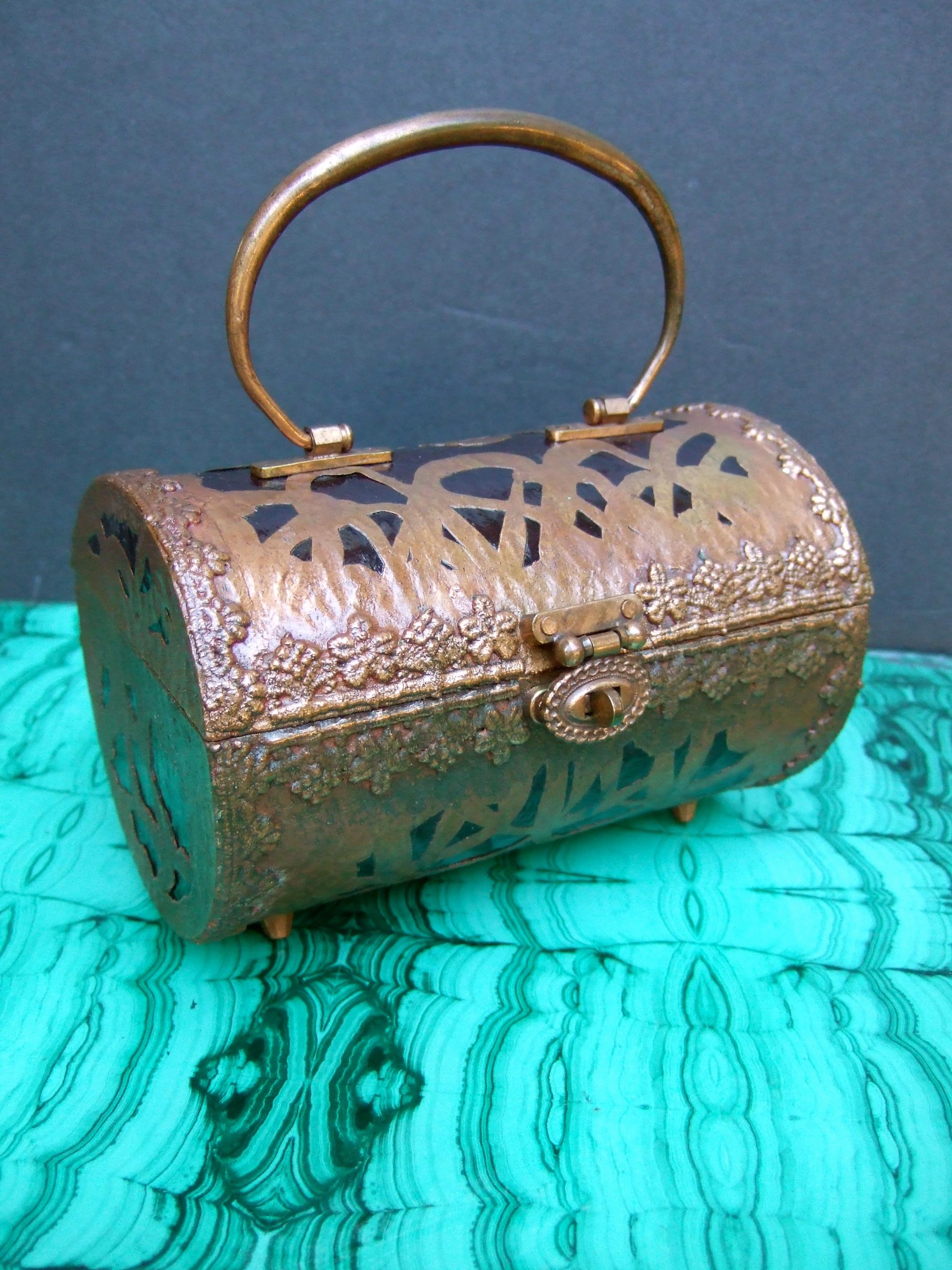 Saks Fifth Avenue Rare copper metal lucite cylinder handbag c 1960s
The unique barrel shaped handbag is adorned with hammered copper metal foliage designs in the style of the early 20th century arts & crafts movement  
The border edges are