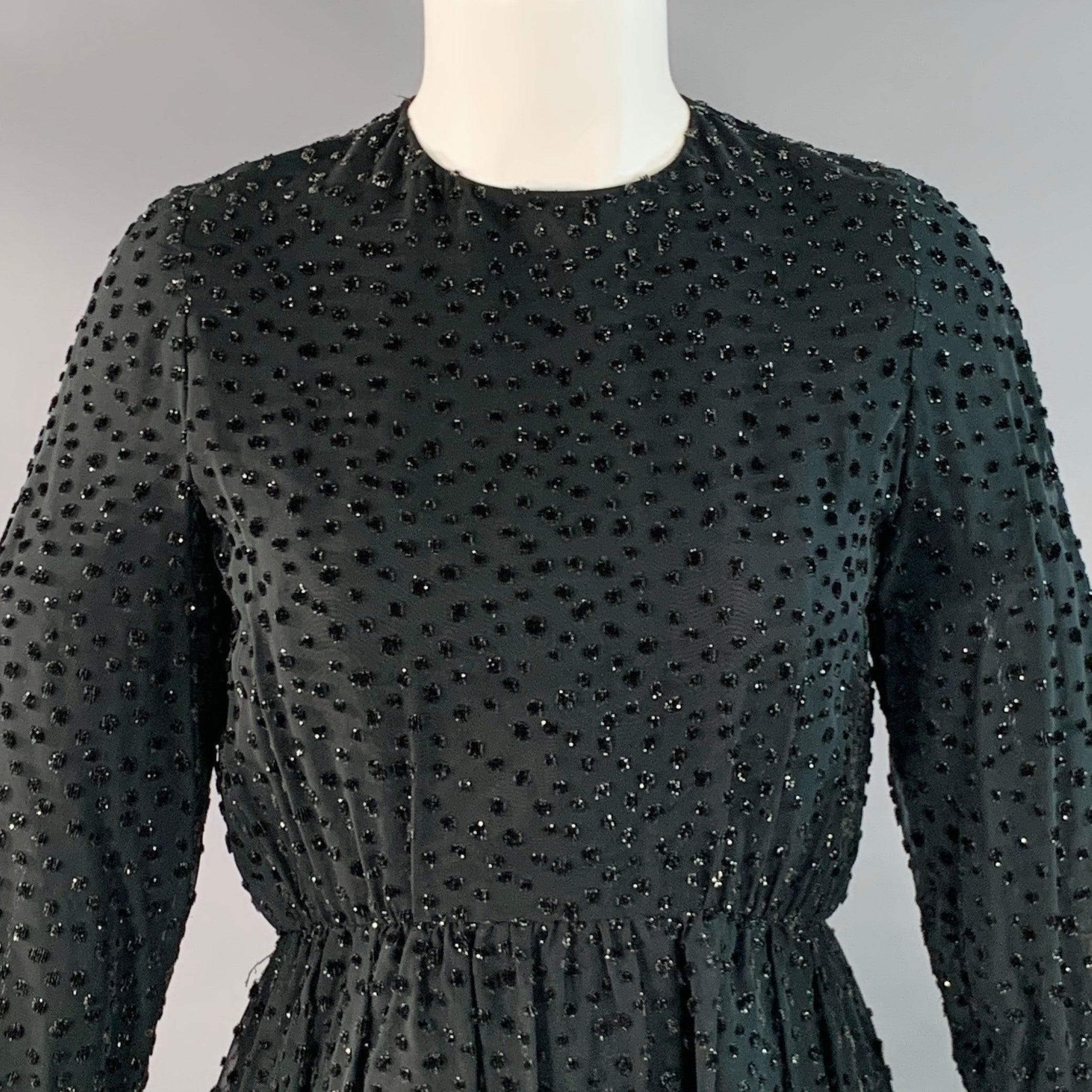 SAKS FIFTH AVENUE - Robe de cocktail
en polyester noir, avec un motif texturé à pois, une jupe trapèze et des bordures en plumes d'autruche aux poignets et à l'ourlet.Très bon état d'occasion. Signes d'usure sur la frange. 

Marqué :   taille non