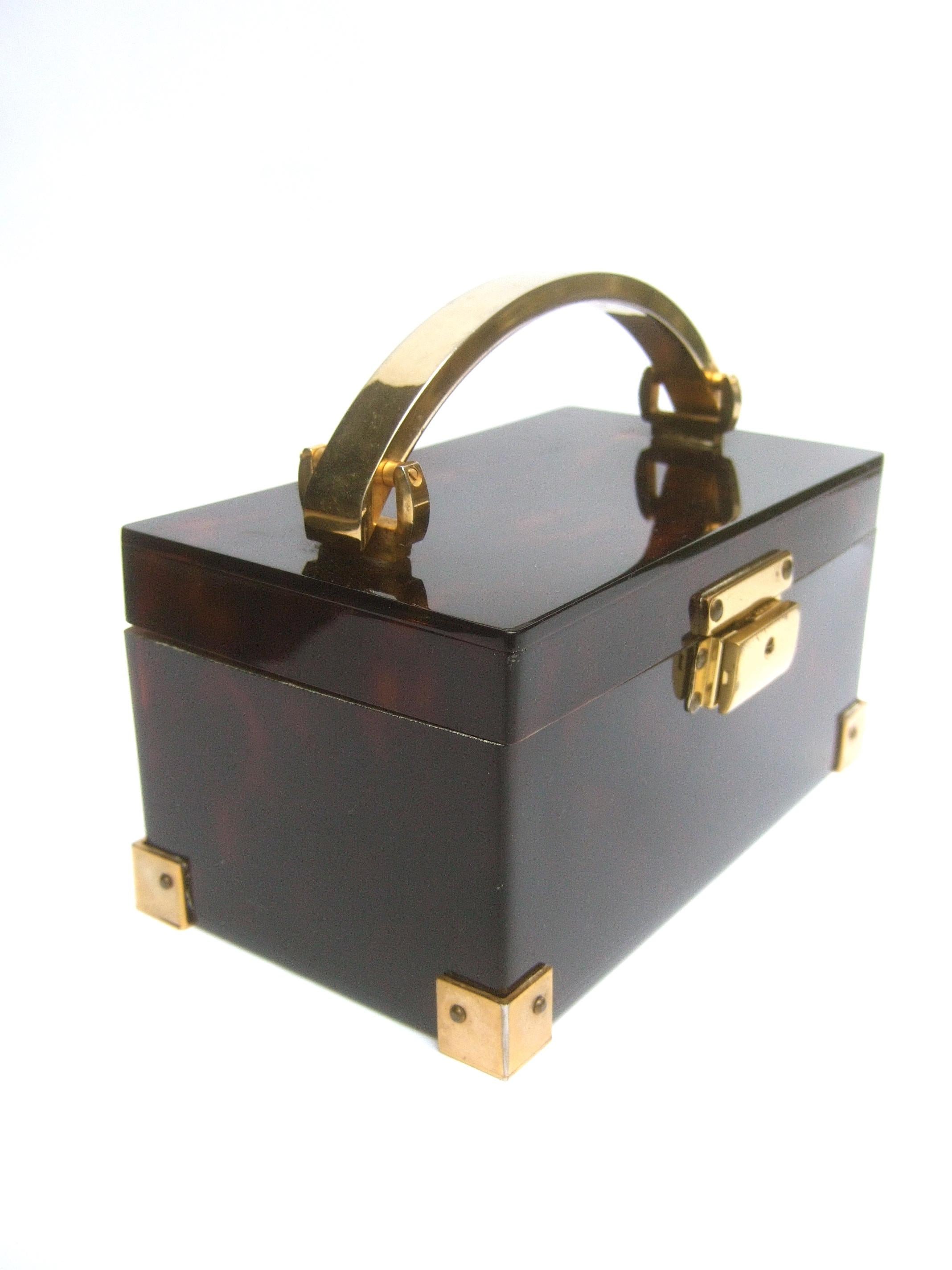 Saks Fifth Avenue Sleek tortoise-shell lucite box purse c 1970s
The stylish vintage box purse is constructed with dark brown lucite opaque panels; 
against light shows the subtle tortoise-shell design

Adorned with a sleek gilt metal stationary