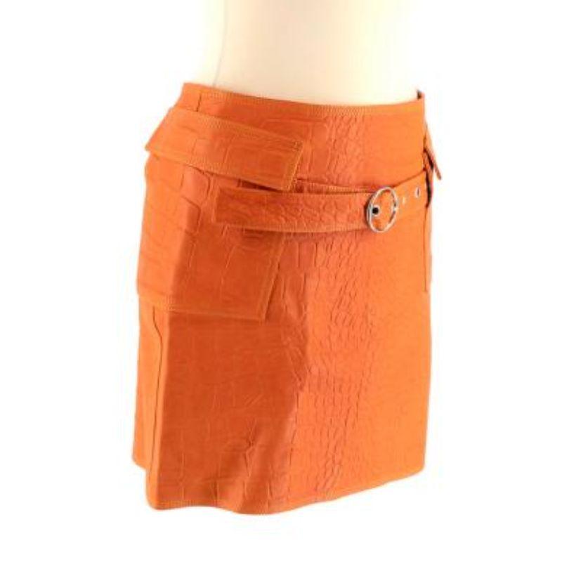 Sak Potts New York Orange Crocodile Embossed Leather Skirt

- SS '22
- Mid weight lambskin leather body
- Embossed crocodile all over pattern 
- Patch pockets 
- Belt detail 
- Mini length
- Back concealed zip fastening 
- Fully lined with brown