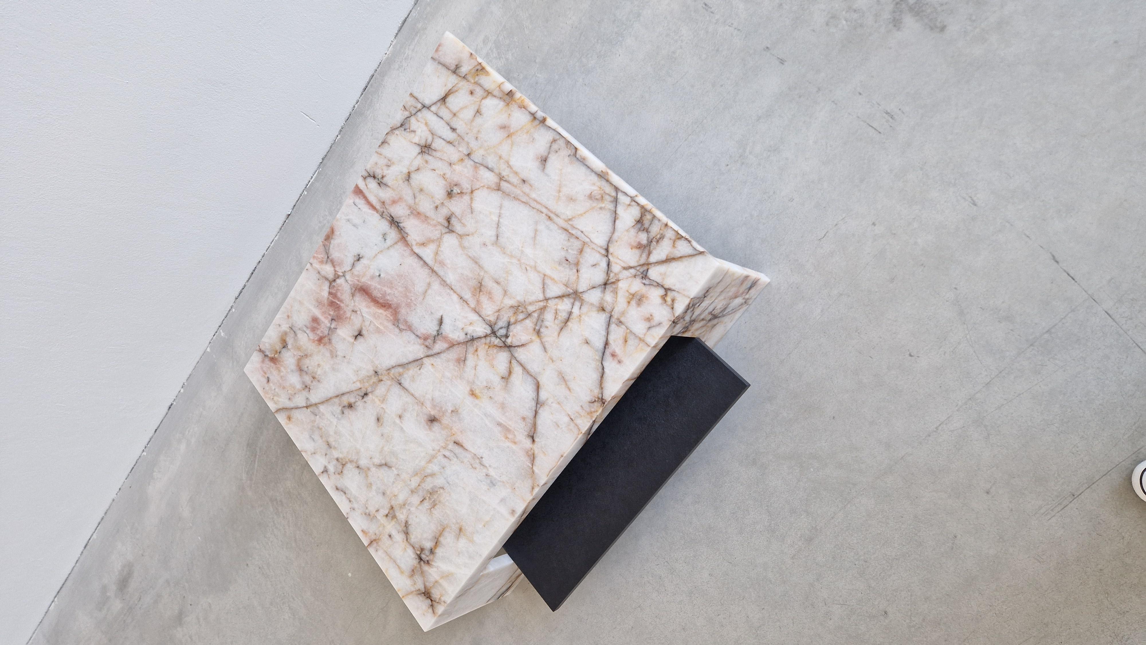 La table SAKURA de la Collection Origami est un chef-d'œuvre sculptural inspiré par l'art délicat du pliage de papier japonais. Son design frappant est composé de deux formes angulaires qui se croisent dans une harmonie dynamique, évoquant