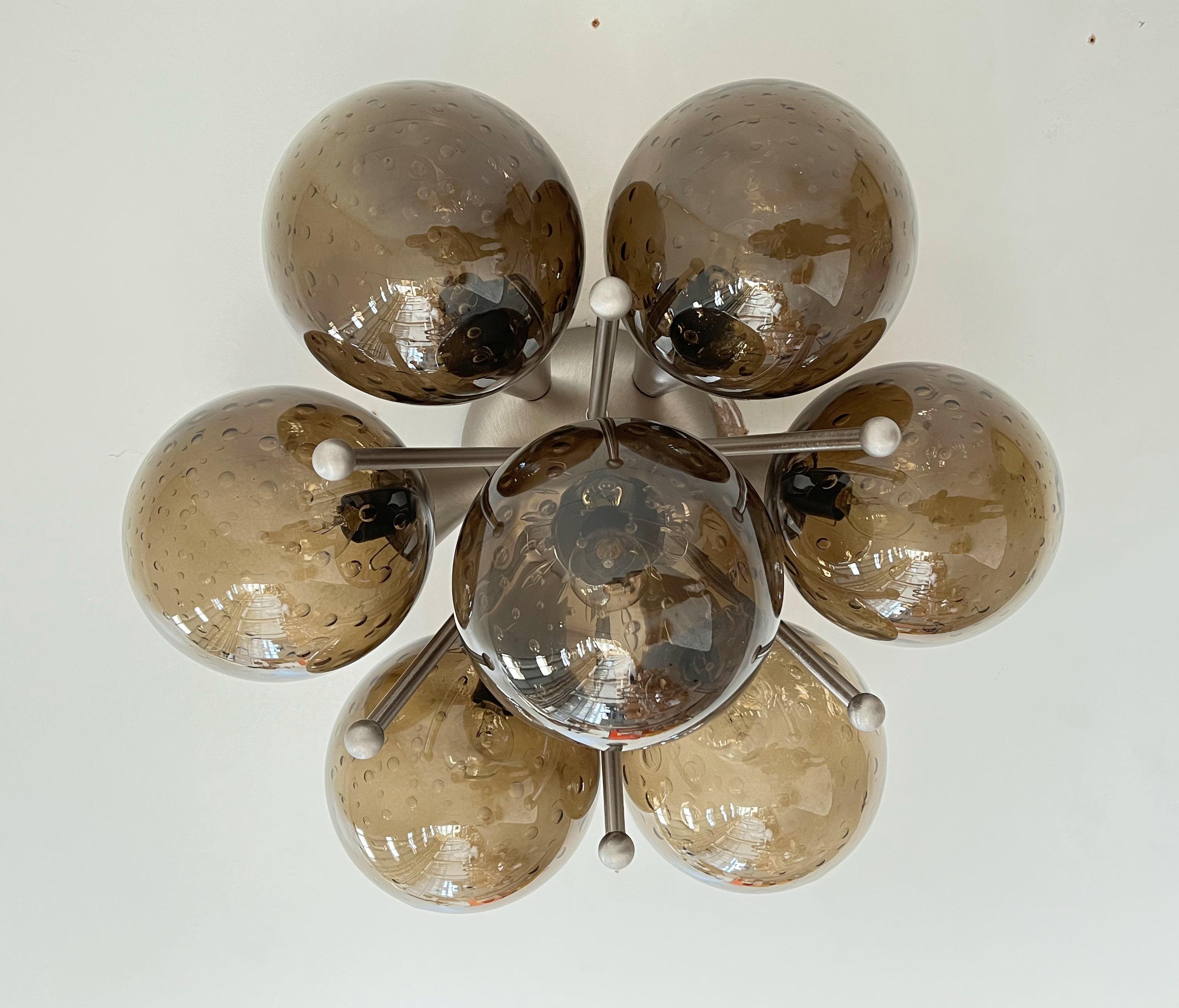 Empotrable italiano con globos de cristal de Murano montados en marco de latón macizo
Diseñado por Fabio Bergomi / Fabricado en Italia
7 luces / tipo E12 o E14 / máx. 40W cada una
Diámetro: 22 pulgadas / Altura: 11 pulgadas
Sólo pedido / Este
