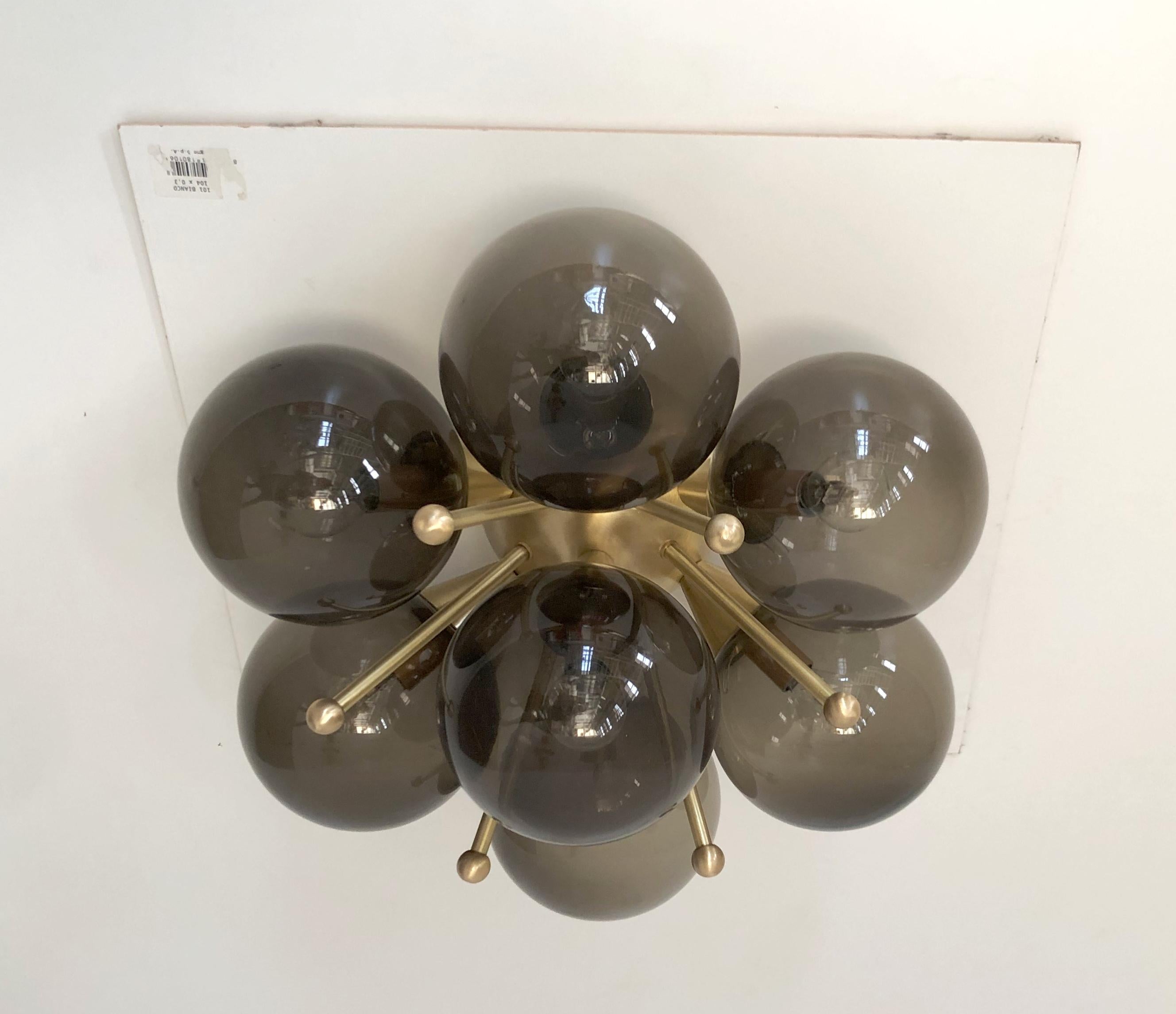 Italian flush mount with murano glass globes mounted on solid brass frame.
Designed by Fabio Bergomi / made in Italy.
7 lights / E12 or E14 type / max 40W each.
Measures: diameter: 22 inches / height: 11 inches.
Order only / this item ships from