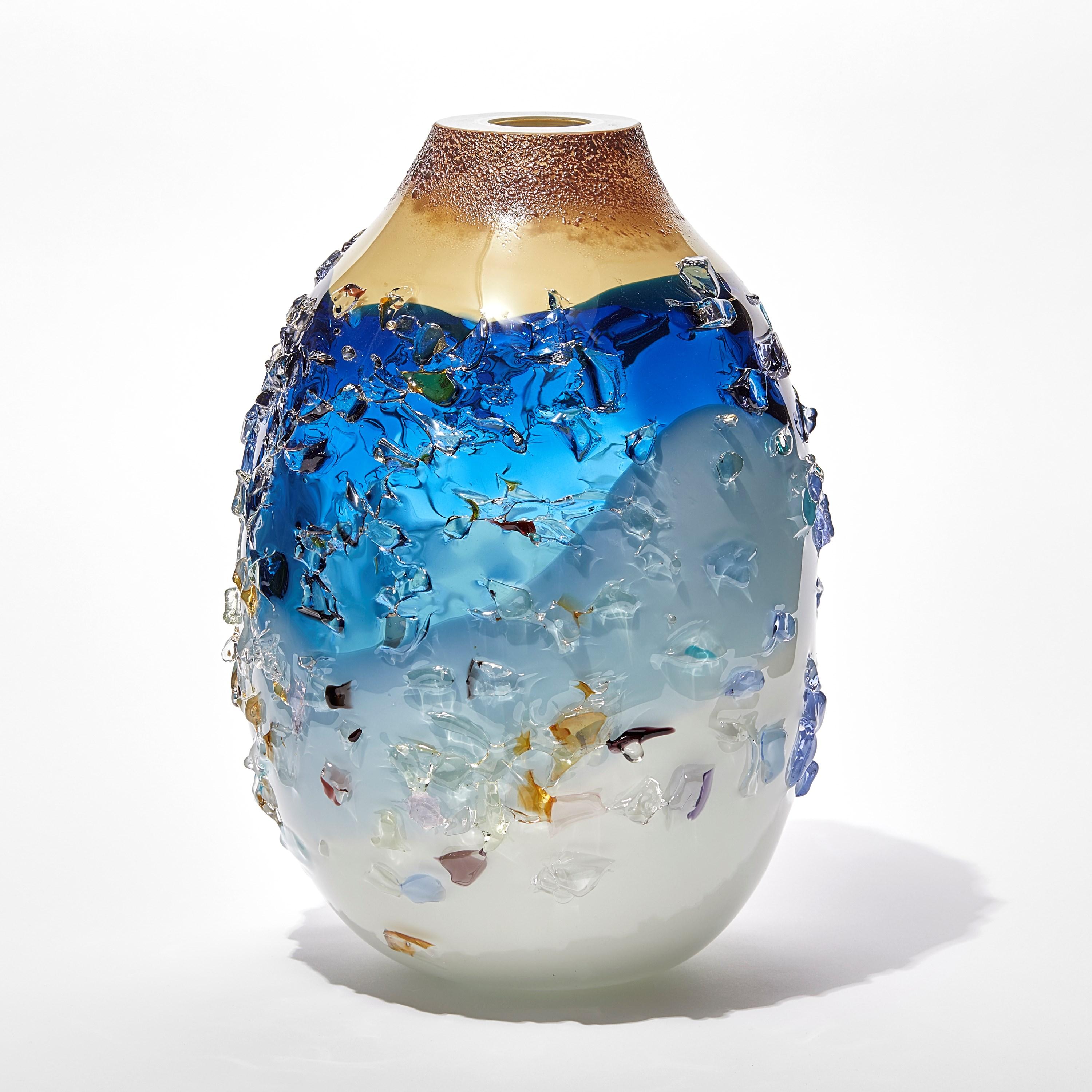Sakura TFO23028 ist eine einzigartige Vase aus mundgeblasenem, skulpturalem Kunstglas in zartem Blau, Aqua, Creme und Mehrfarben, überzogen mit einer organischen Glasscherbenverzierung des niederländischen Künstlers Maarten Vorlijk. Das Stück ist