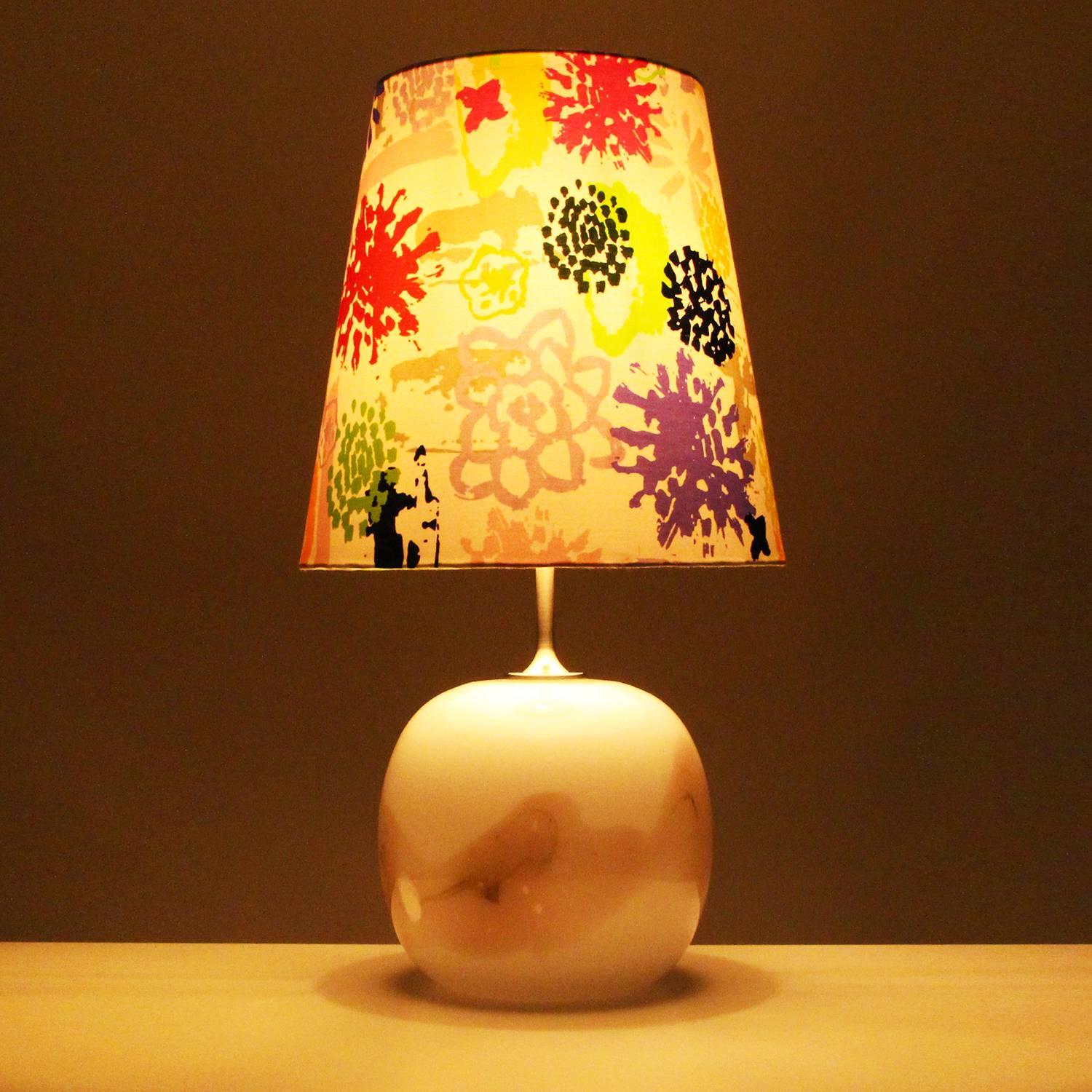 Sakura, large blown glass table lamp by Michael Bang in 1980 for Holmegaard Glassworks, beautiful milky white and rose lamp stand with large colorful shade included, all in very good vintage condition.

This large round lamp stand is made up of