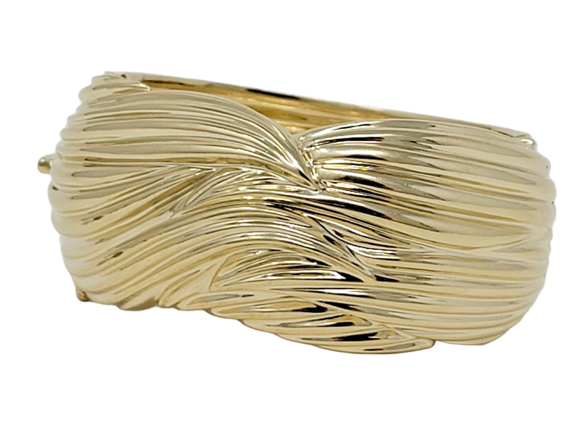 Bold, contemporary Sal Praschnik statement piece that fills the wrist with style. Elevate your common cuff style into this unique statement piece! Featuring a wide, polished 14 karat yellow gold construction with a textured design throughout the