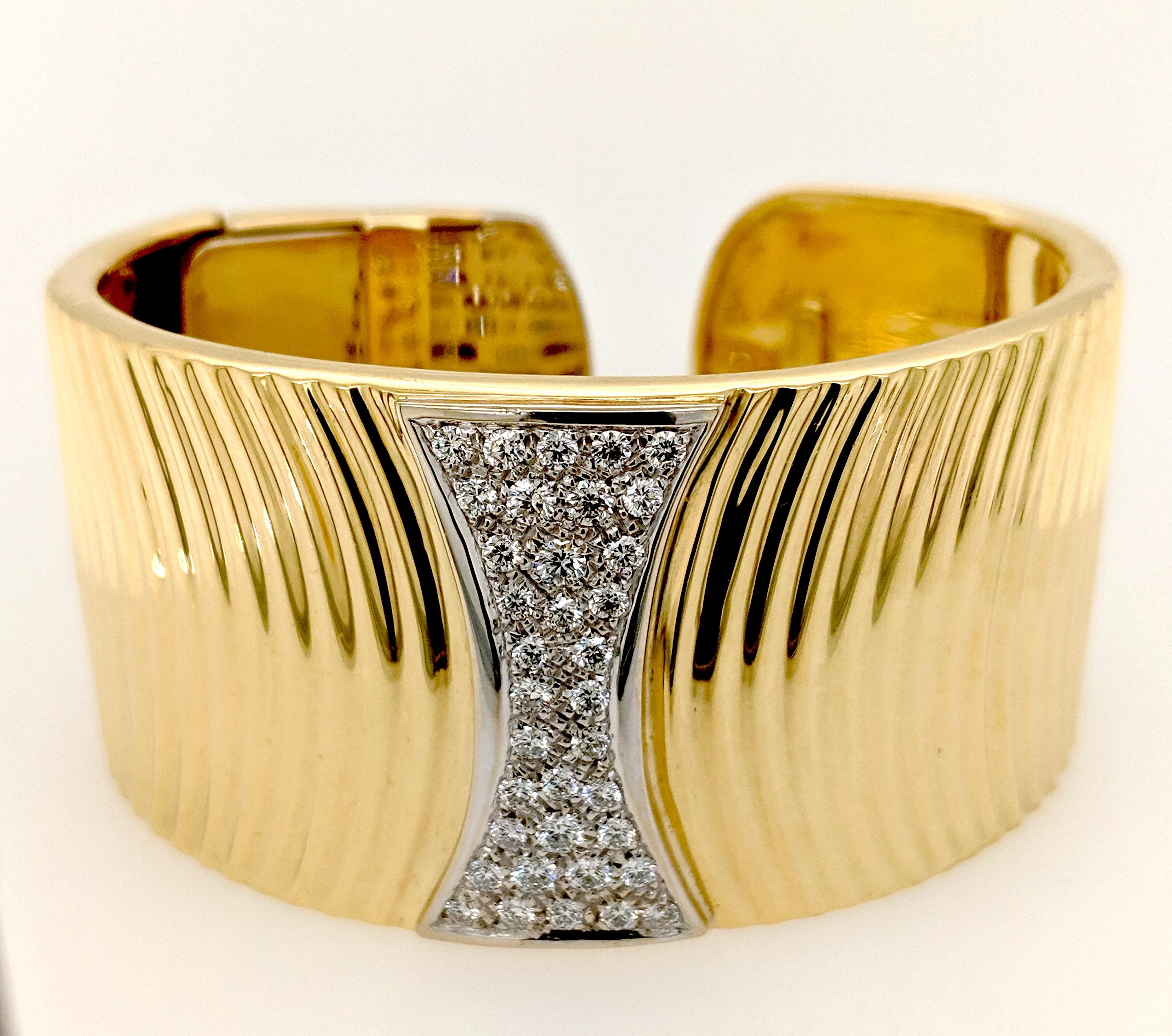 The Diamond cuff bracelet designed by Sal Praschnik is crafted in 18 karat yellow gold and features (37) round diamonds weighing 1.41cttw with a color of G/H and a clarity of SI1. The bracelet is 1, 1/4
