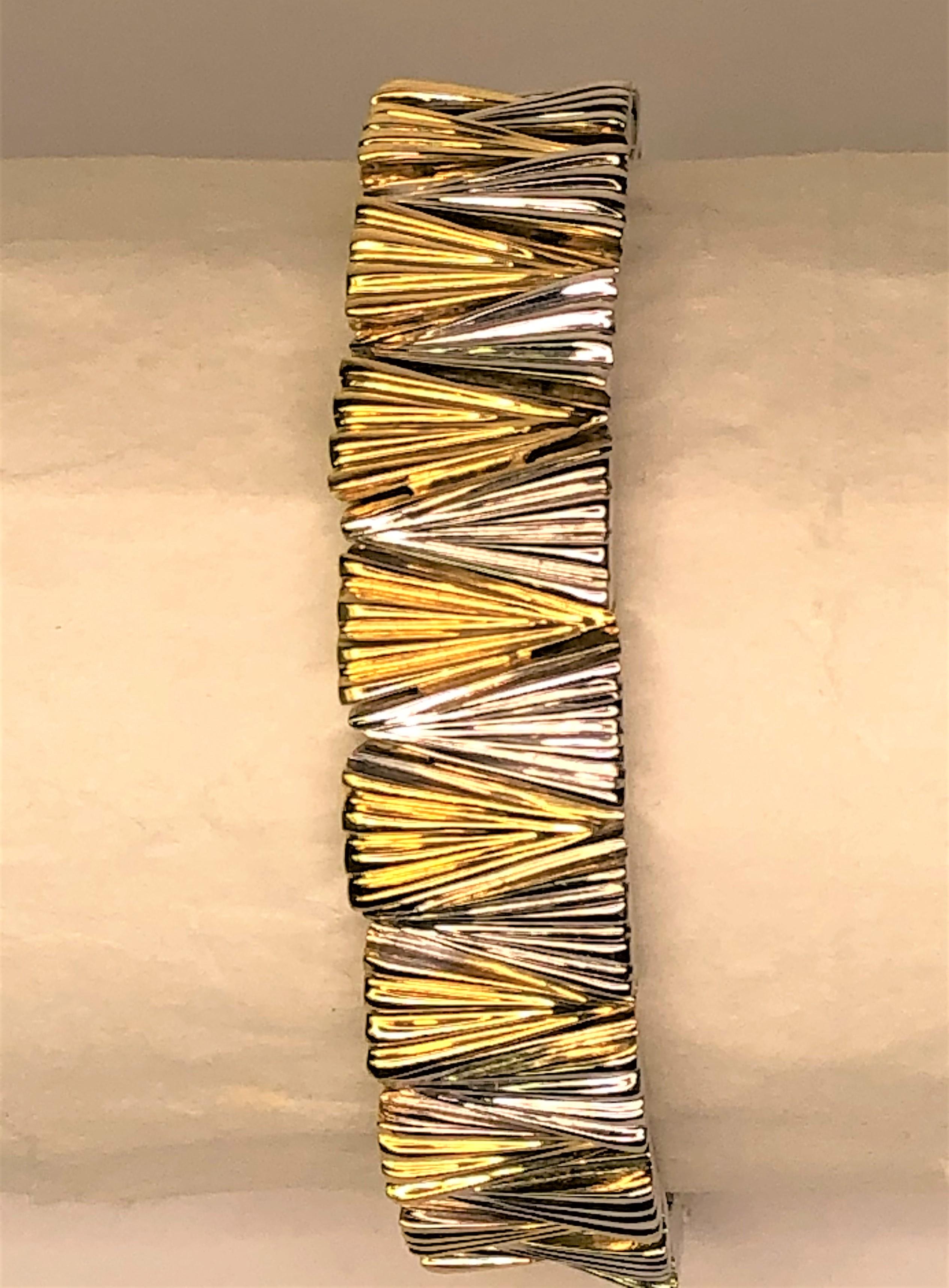 This bracelet is fabulous and will shine no matter what you are wearing!
Designer Sal Praschnik
18 karat yellow and white gold, weighing approximately 49.2dwt
35 triangular shaped pieces alternating in white and yellow gold plus white gold