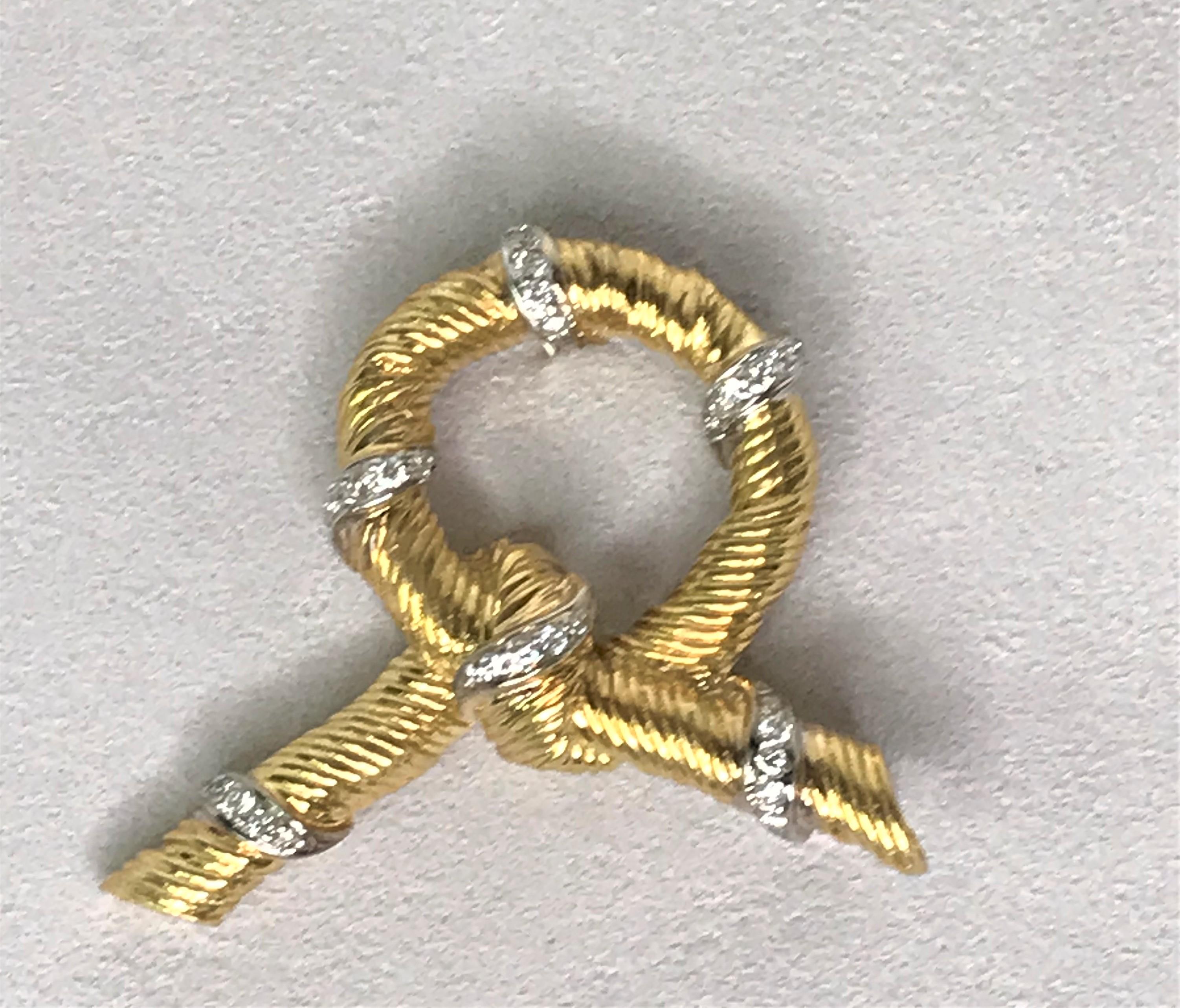 This piece shines and sparkles! 
18 karat yellow and white gold ribbed bow design.
Six stations of diamonds set in 18 karat white gold.  
30 round full cut diamonds, approximately .30tdw, VS-SI clarity, G-H color.
Stick pin with safety.
Overall