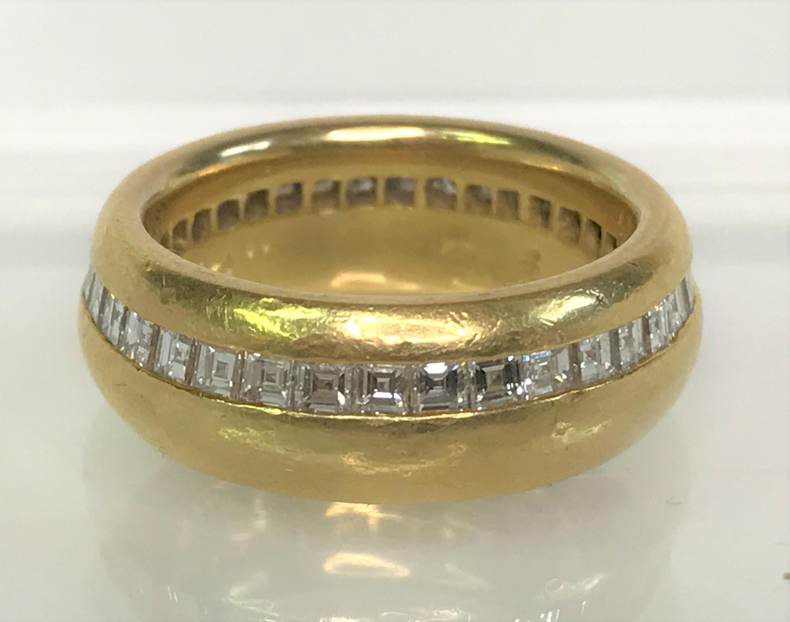By designer Sal Praschnik, this beautiful band ring will get lots of compliments.  
18 karat solid yellow gold.  Weighs 10dwt 
Approximately 8mm wide with diamonds all the way around, set in a straight line slightly off-center
35 square step cut