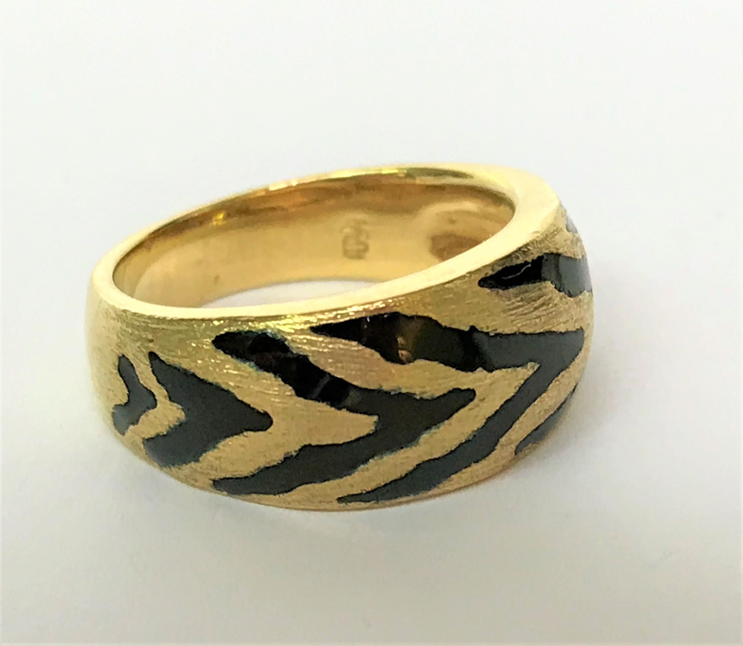 By designer Sal Praschnik, Inc. 
18 karat yellow gold and black enamel band.
Ring graduates from approximately 9mm at top to 5mm at bottom.
Black enamel 'tiger stripes' with brushed gold on top half of band.
Bottom half of ring is polished. 