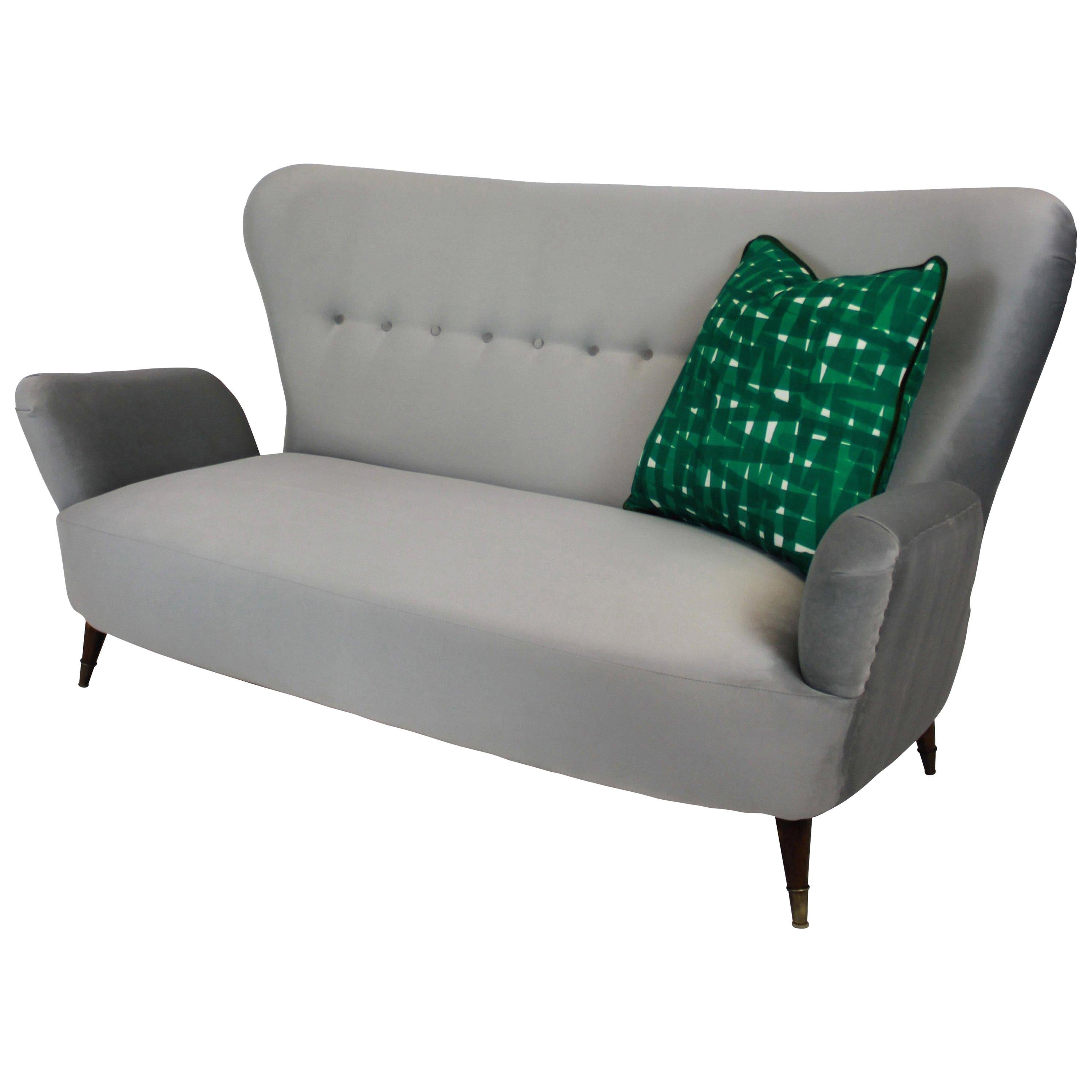 A stylish Italian sofa of good shape with tapering legs and brass sabot by Emilia Sala and Giorgio Madini (Designer), Fratelli Galimberti Cantù (Manufacturer). Newly upholstered in silver grey velvet, with seat cushions removed for better