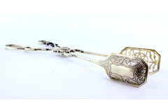 Salad, bread or sauce tongs in cut-out silver