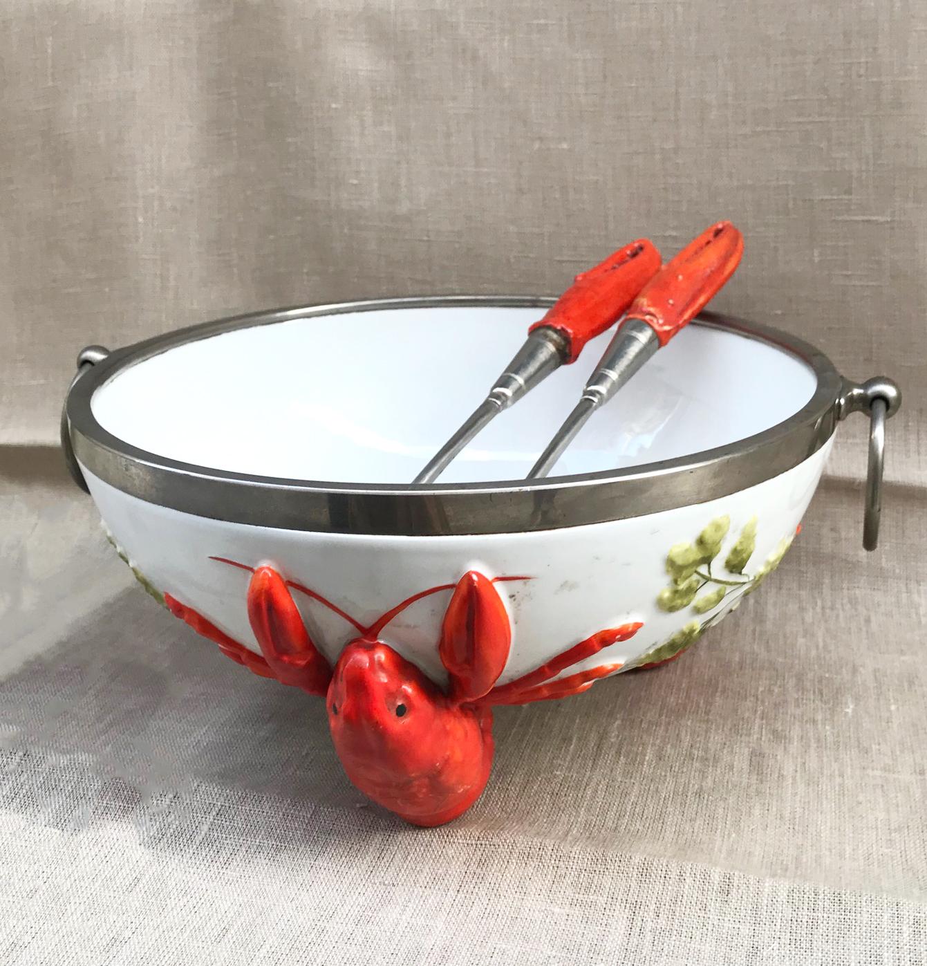 Outstanding three-piece salad set from Musterschutz.
This rare set includes:
1- Salad bowl: White-based salad bowl with lobster figures. The piece has on its upper edge a metal ring and is signed at its base with the signature of the company