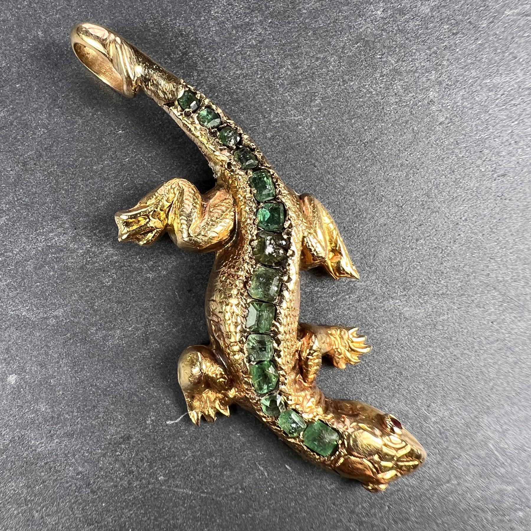 A realistically modelled antique salamander or lizard pendant in 18 karat (18K) yellow gold with chased scale detail, set with 14 emerald cut emeralds to the spine, with cabochon ruby eyes. The emeralds are somewhat abraded, but estimated to weigh a