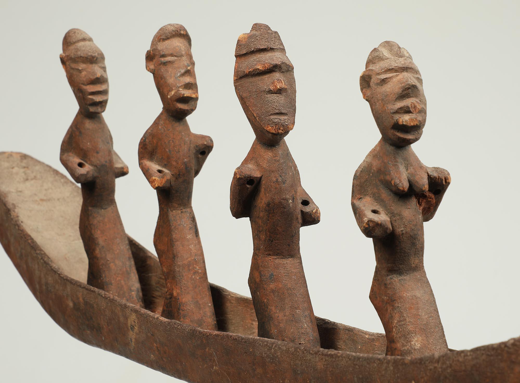 Très rare assemblage de sculptures en bois sculpté représentant un bateau avec une rangée de personnages debout, le second portant le masque classique du peuple Salampasu, de la République démocratique du Congo. Les figurines sont fixées au fond du