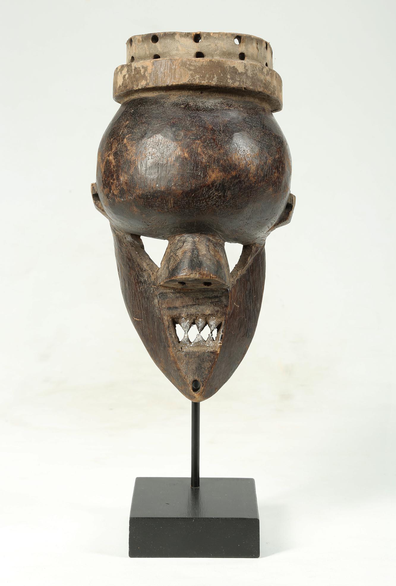 Salampasu warrior mask, Democratic Republic of Congo, Africa, early 20th century. With remains of black and white pigments. Open mouth with pointed teeth, and open triangular eyes. On custom wood and metal stand. Small ones like this are considered