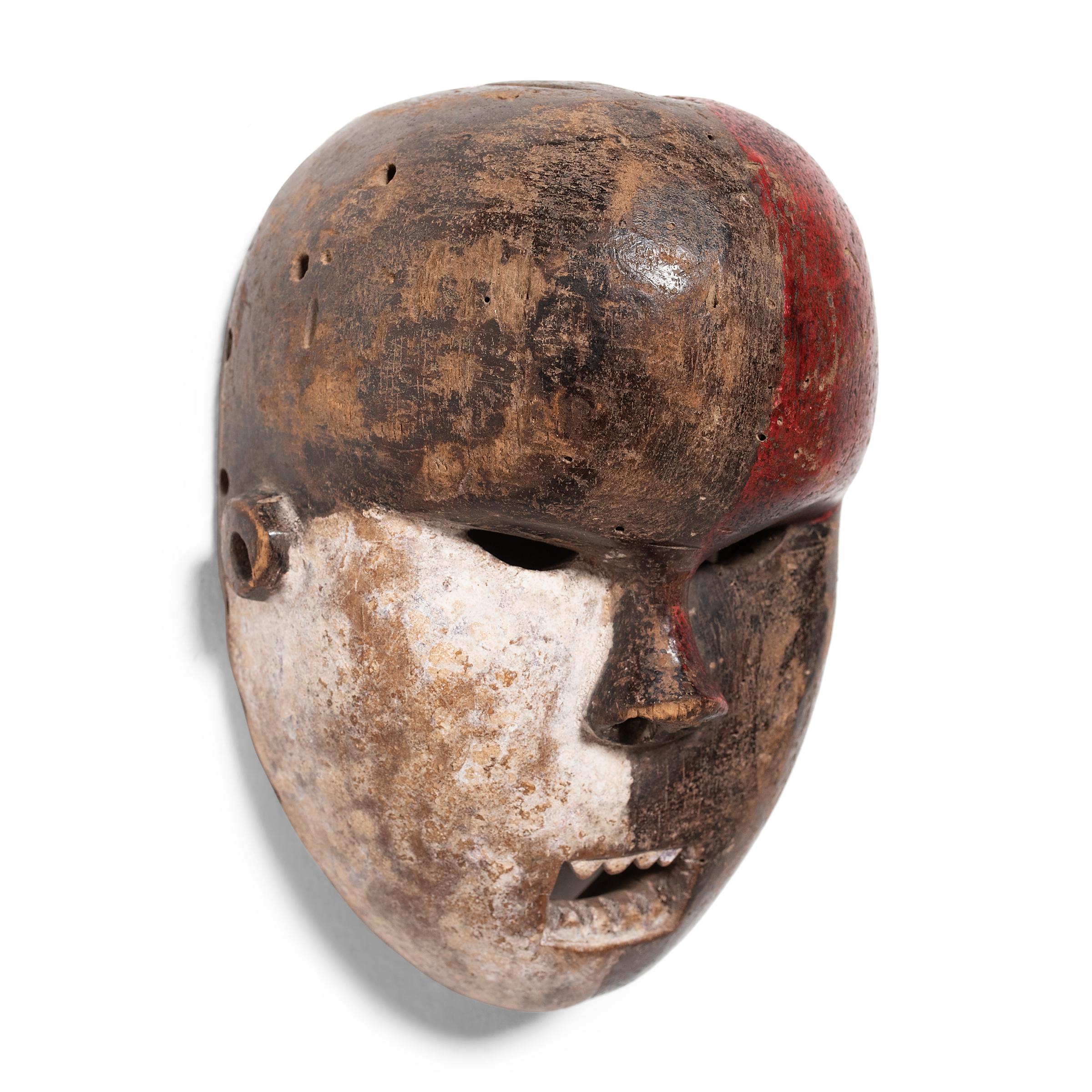 Divided into contrasting tones, this ceremonial African mask is linked to the Salampasu people of the Bantu ethnic group located primarily in the Democratic Republic of Congo. Salampasu masks were an integral part of the men's warrior society whose