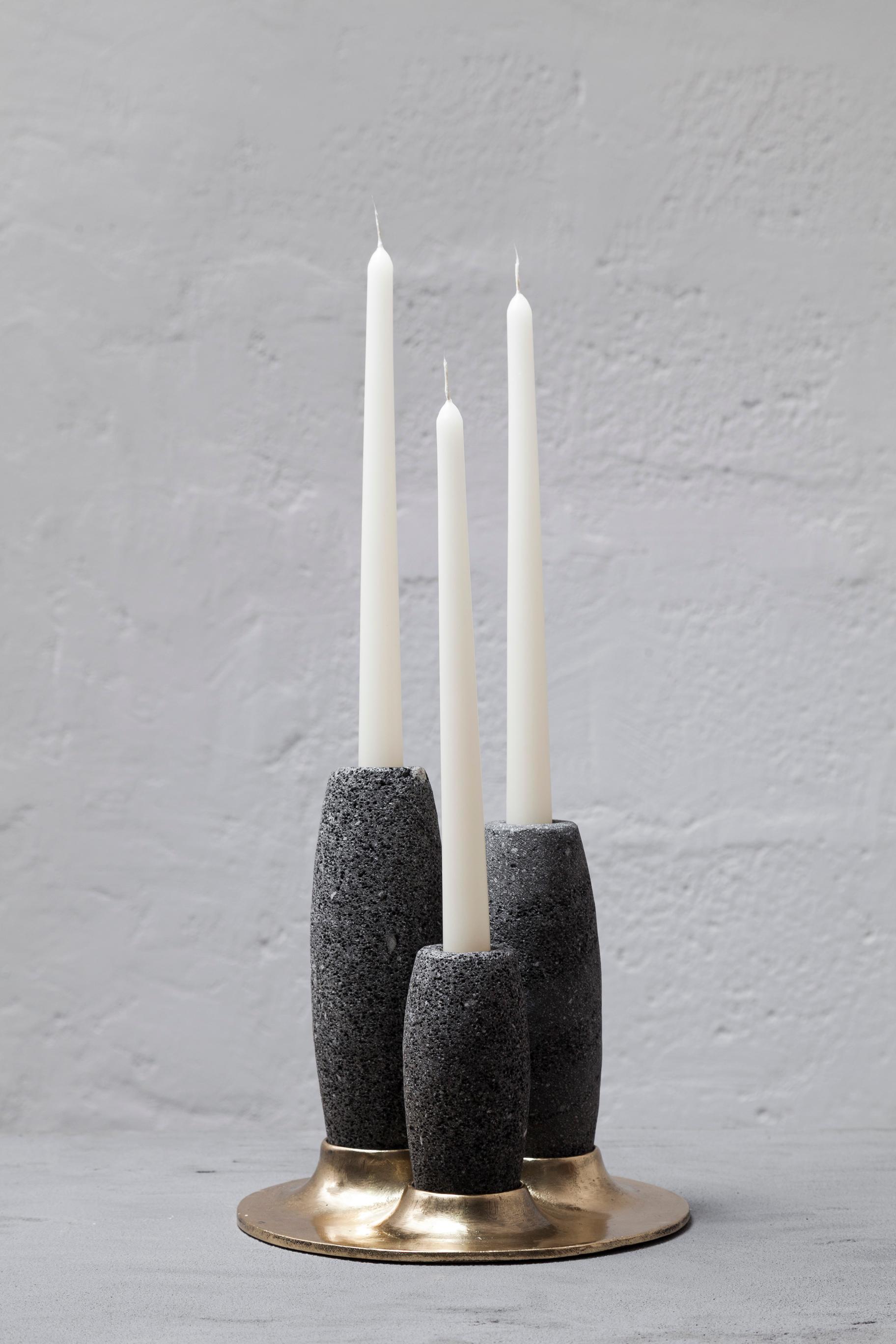 SALAR is a sculptural candle holder, composed of a sand-cast bronze base, and hand-carved volcanic stone candle holders. The shape is a representation of the traditional process used for the production of salt in colonial times. In Salinas de