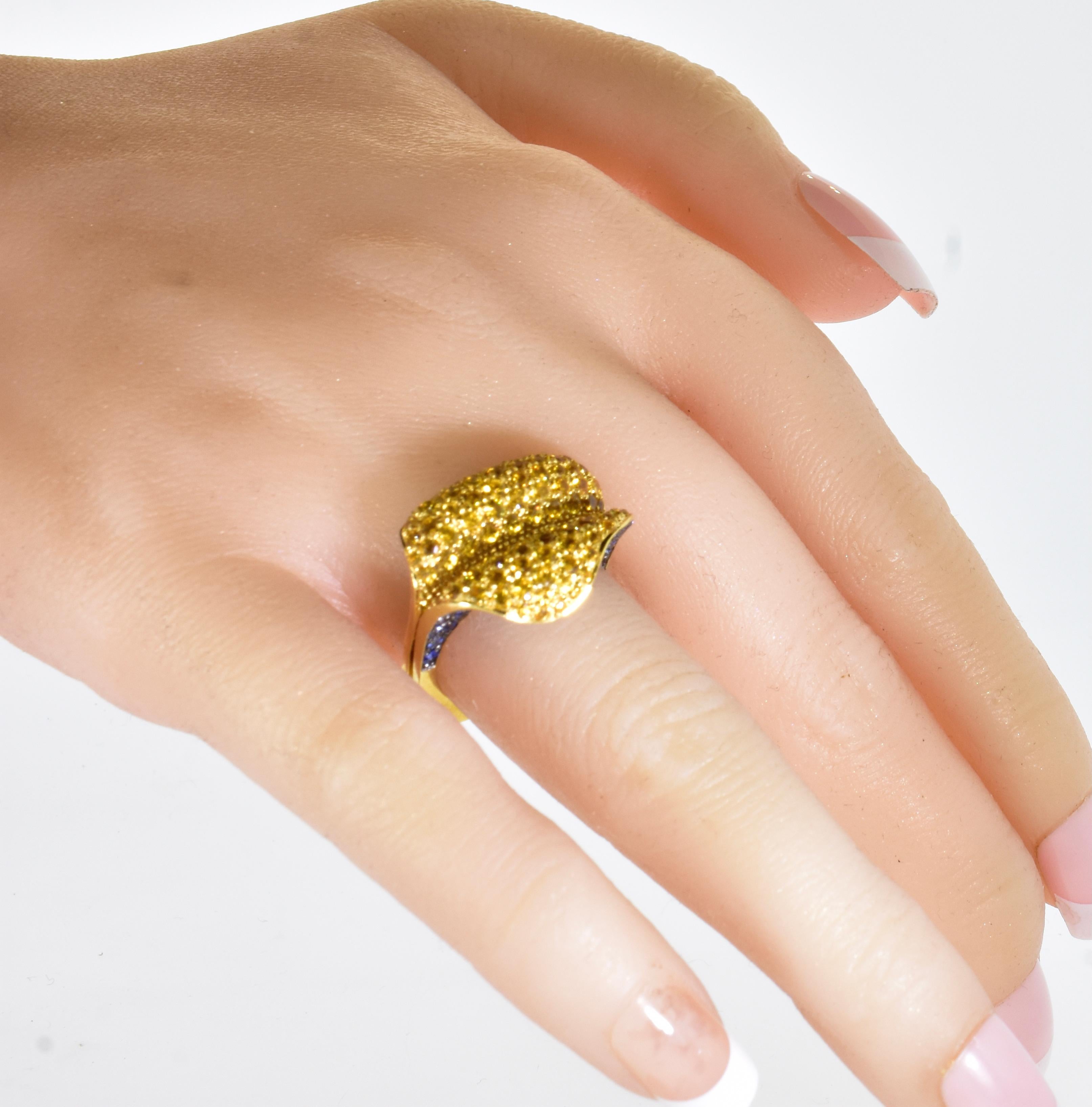 Yellow and blue sapphires set in 18K yellow gold in a very inventive ring by the jewelry designer Salavetti - known for their use of fine materials. The pave set natural golden (yellow) sapphires are a bright pleasing daisy yellow.  The  natural