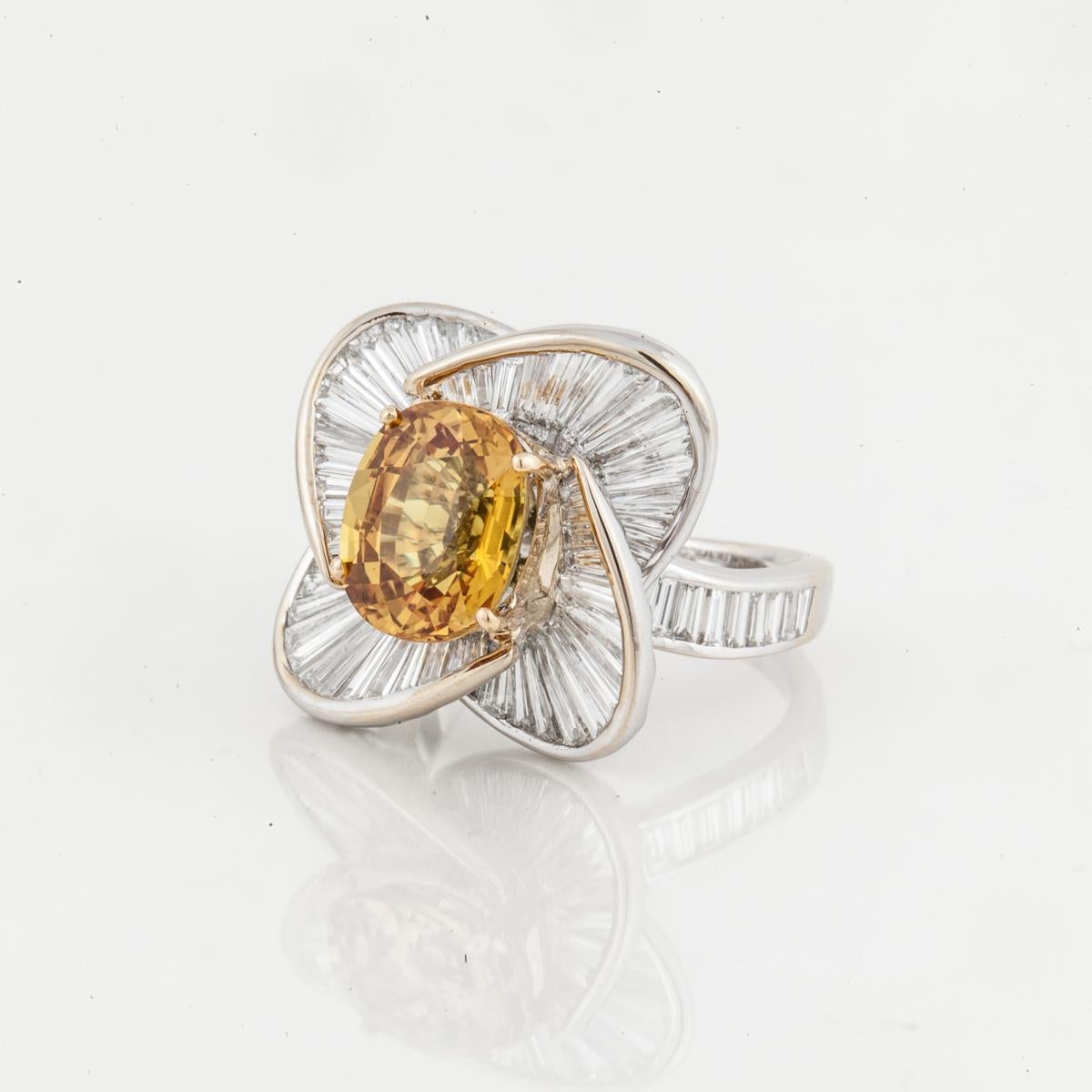 Salavetti 18K white gold ring featuring one oval golden sapphire that totals 4.88 carats.  Surrounding the sapphire and down the shank, are 80 baguette diamonds with a total carat weight of 5.25; G-H color and VVS-VS clarity.  Measures 13/16 inches