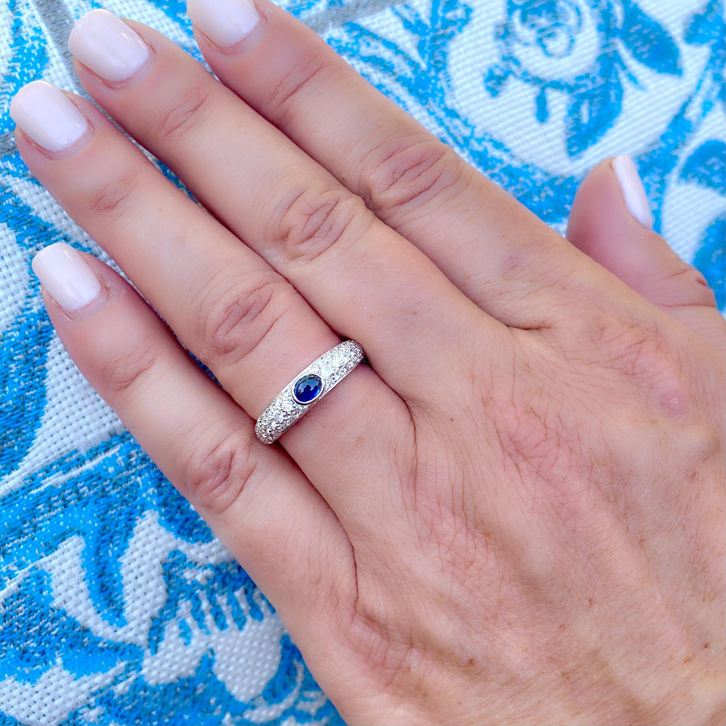 De style classique des années 1970, cette bague à dôme étroit en or blanc 18k est centrée sur un saphir ovale cabochon serti en lunette pesant 0,37 ct, avec des diamants ronds taille brillant sertis en pavage pesant au total 0,63 ct. La bague pèse