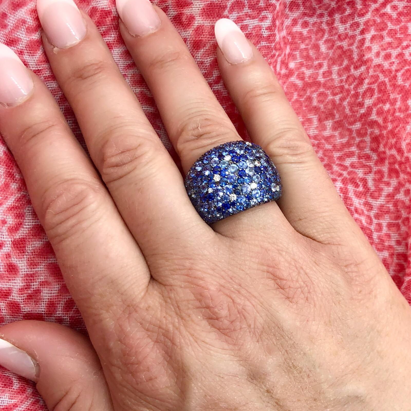 Bold and beautiful, this statement ring by Salavetti is a great find! The wide 18k white gold ring is pave-set with multi-hued blue sapphires totaling 9.04 carats and round brilliant-cut diamonds totaling 0.21 carat. The ring weighs 17.0 grams,