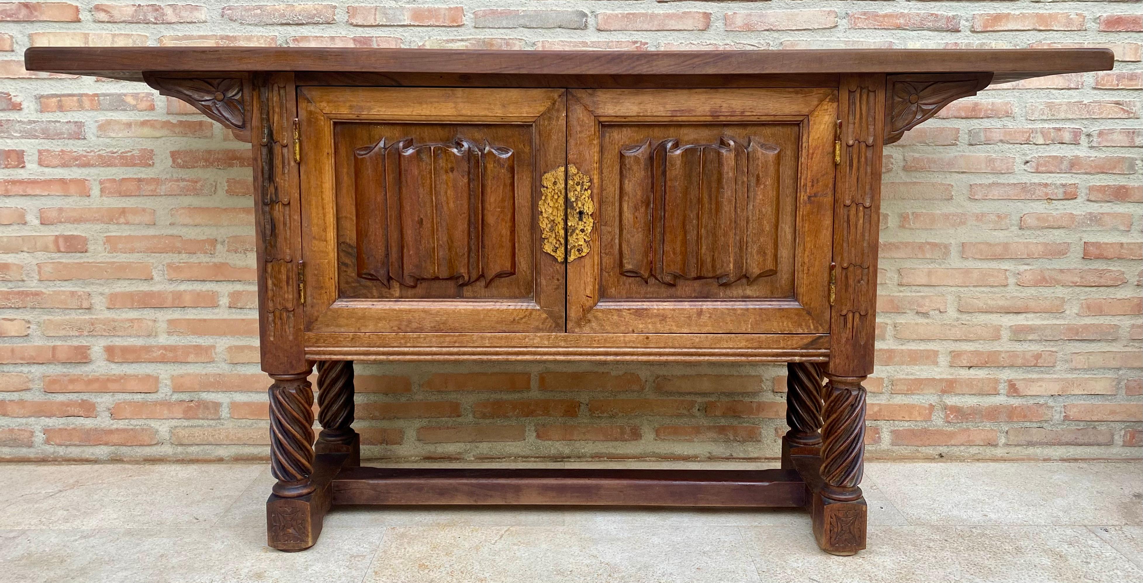 Very good quality carved Spanish console, circa 1940. Beautifully carved from walnut, with good color and patina. It features two carved panels on the doors, with carved leaf decoration. The piece has decorated side pilasters and a double-door
