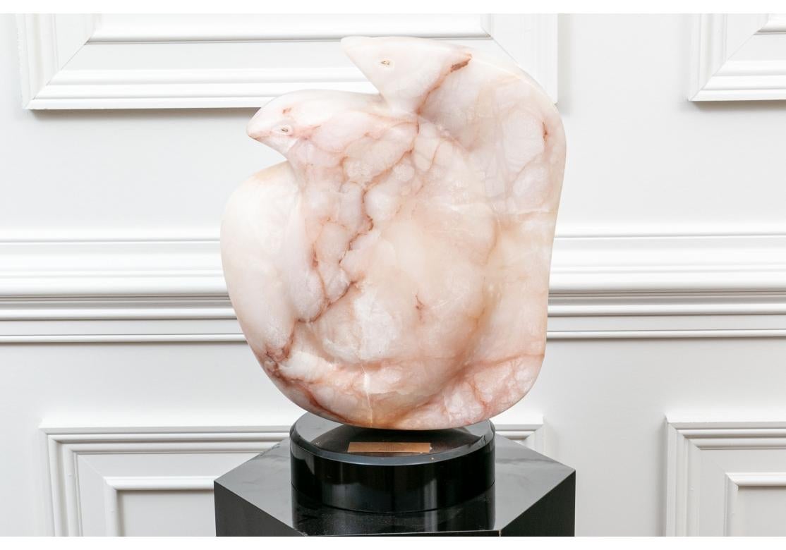 Scultura astratta in alabastro rosa venato a doppia curvatura con teste di uccelli visibili sulla parte superiore. Montato su una base rotonda rotante nera personalizzata che poggia su una colonna ottagonale laccata nera. 

Dimensioni: 52,75