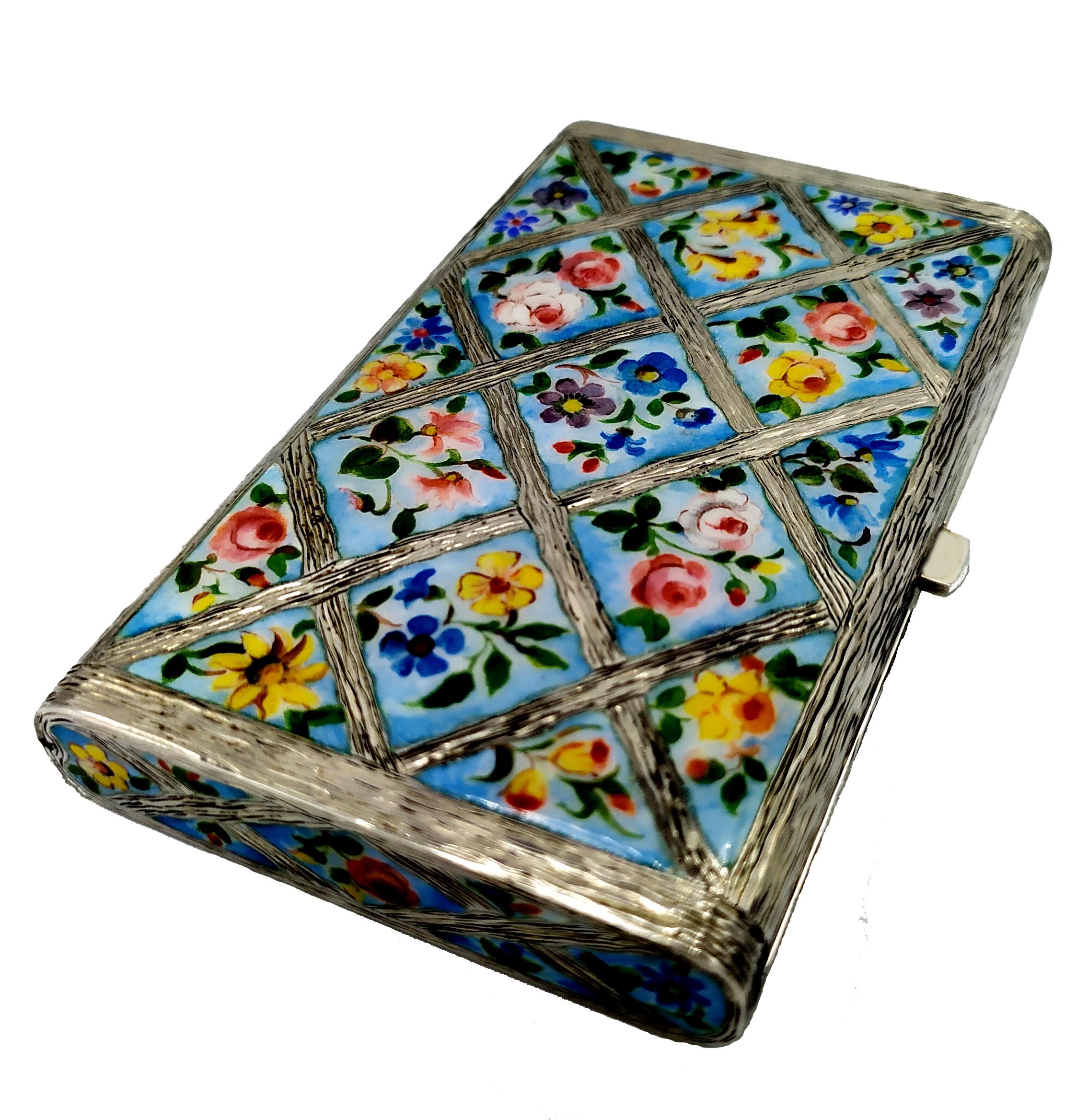 925/1000 Sterling silver cigarette case with hand-painted fired enamelled floral miniatures inserted in frames with hand-engraved borders, above and below. Jugendstil. Spring-loaded snap opening with button and “lost” hinge, ie semi-invisible.