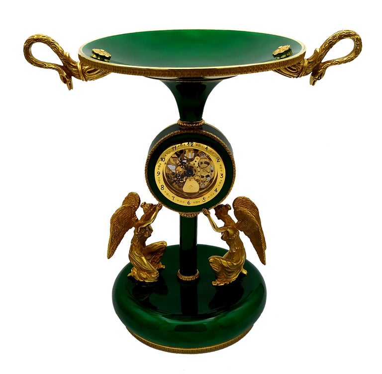 Large centerpiece with clock in 925/1000 sterling silver gold plated with translucent fired enamels on guillochè. With sculptures of winged ladies, Swiss mechanical skeleton movement with alarm, 8 days charge. Friezes and ornaments in the French
