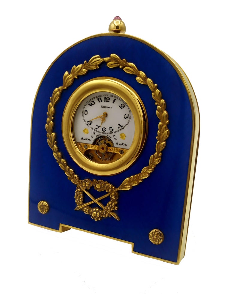 Shaped table clock in 925/1000 sterling silver gold plated with translucent fired enamel on guillochè and Empire style ornaments. Swiss 