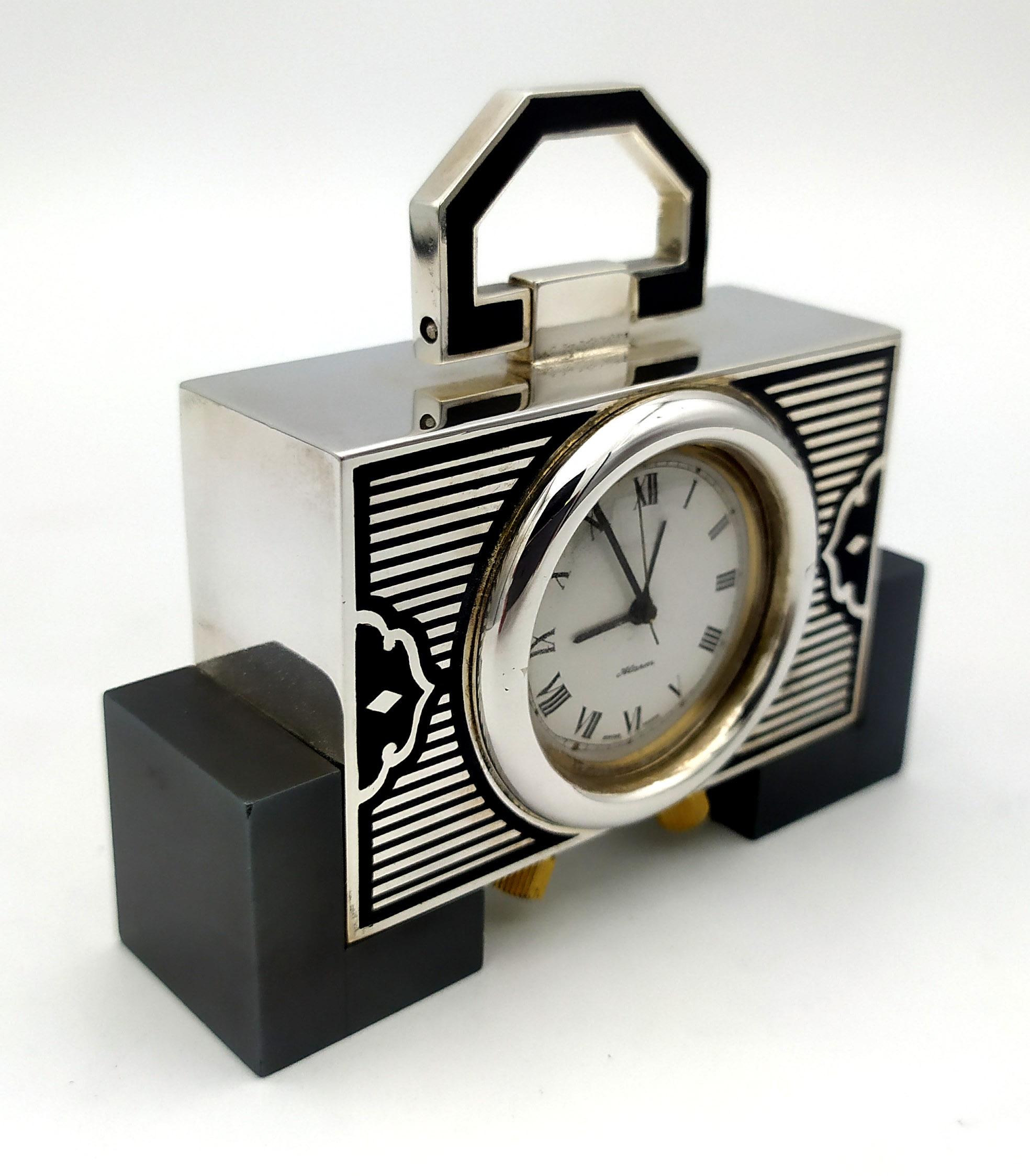 Small travel table clock in 925/1000 sterling silver with Art Deco design fire enameled in black colour. Angular hematite feet. Swiss mechanical movement by Maison Pontifa (Neuchatel) with 8 days charge and alarm. Measures 7.2 x 8 x 2.3 cm. Silver