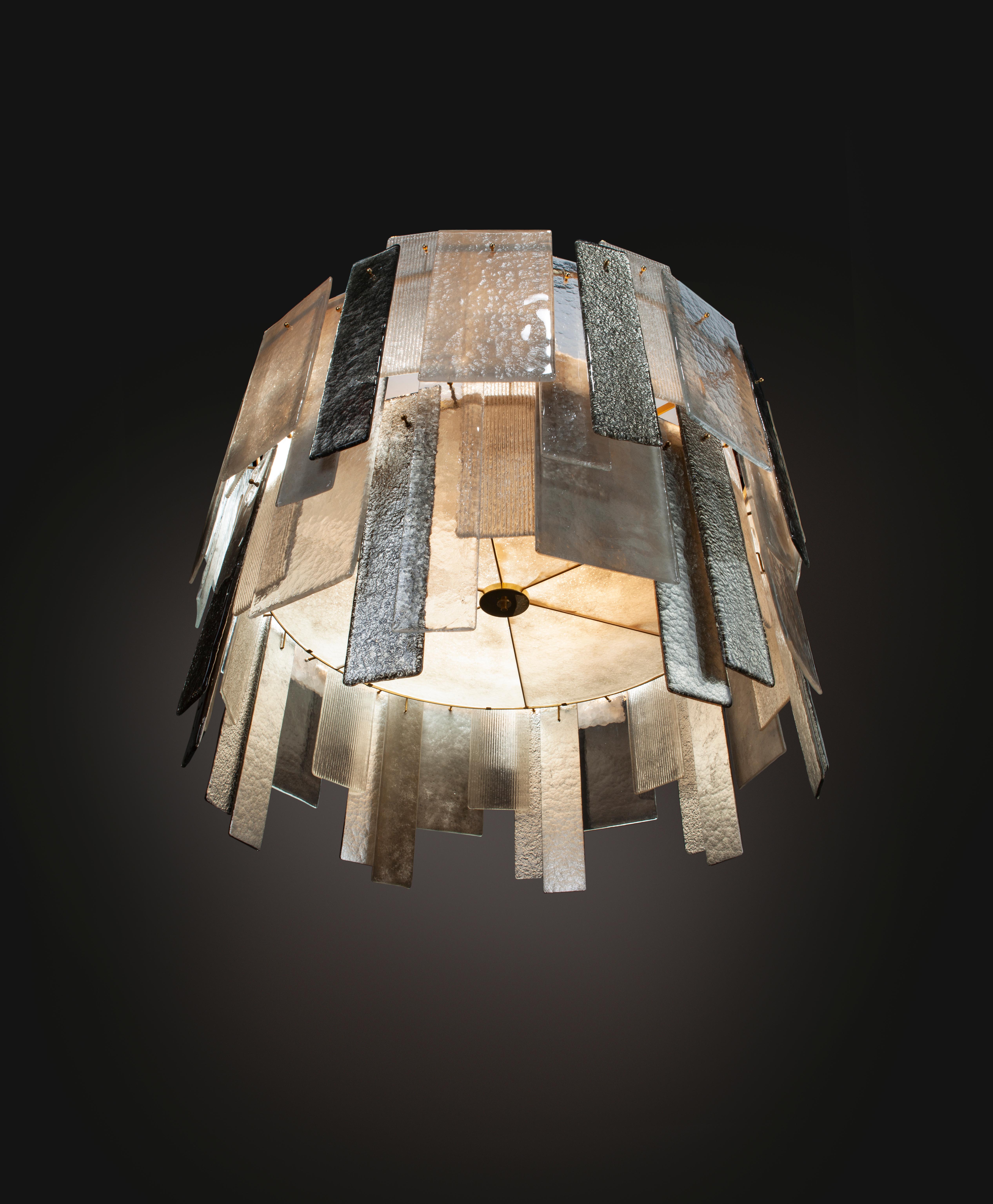 Version de notre populaire lustre Stromboli, le Salina utilise les mêmes panneaux de verre de Murano flottés à la main sur un cadre circulaire revêtu de poudre d'or. La hauteur est réduite par rapport au Stromboli, ce qui le rend plus adapté aux