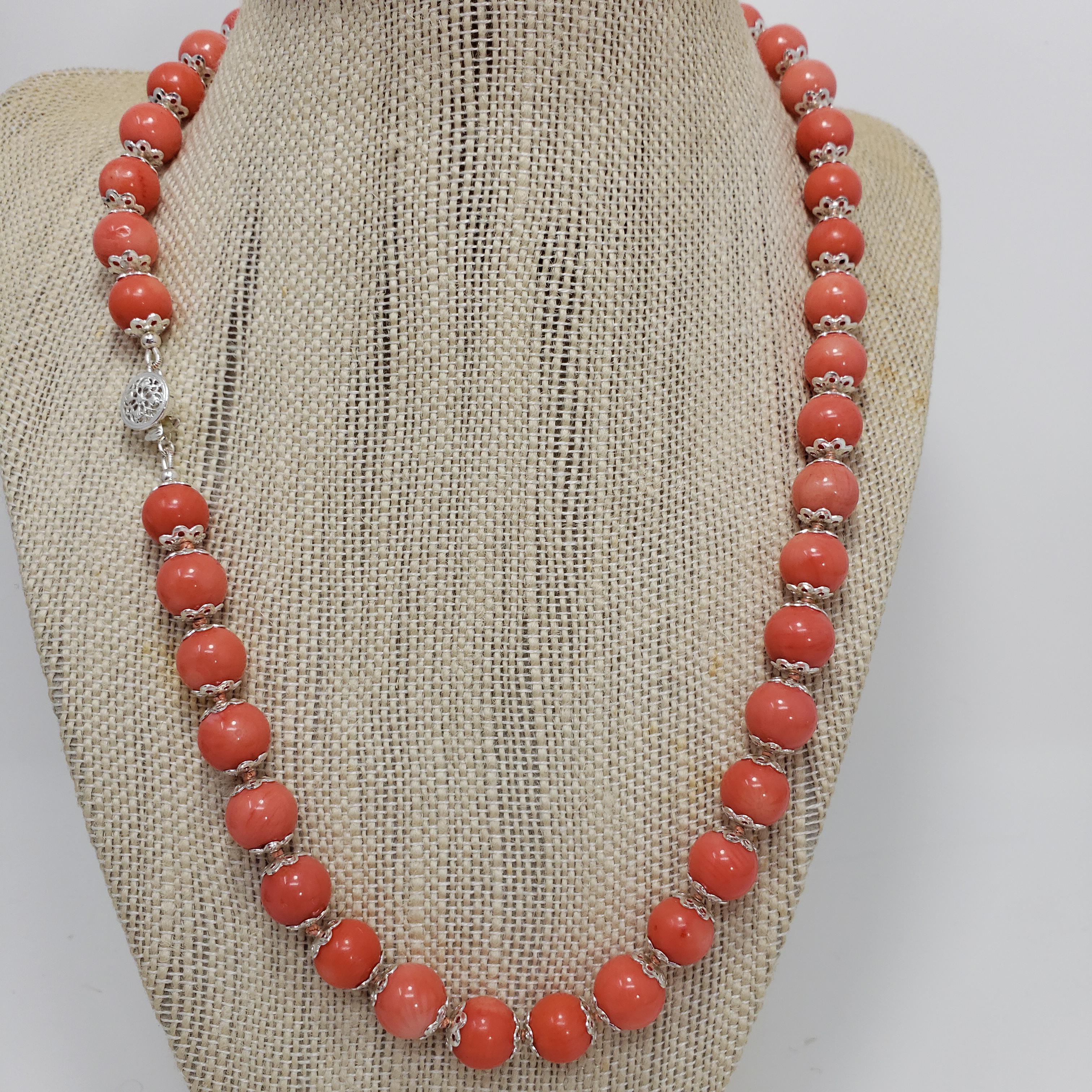 A luxurious beaded salmon coral necklace, decorated with sterling silver accents and a filigree clasp. Fit for royalty!

Hallmarks: 925
Each bead approximately 10mm in diameter