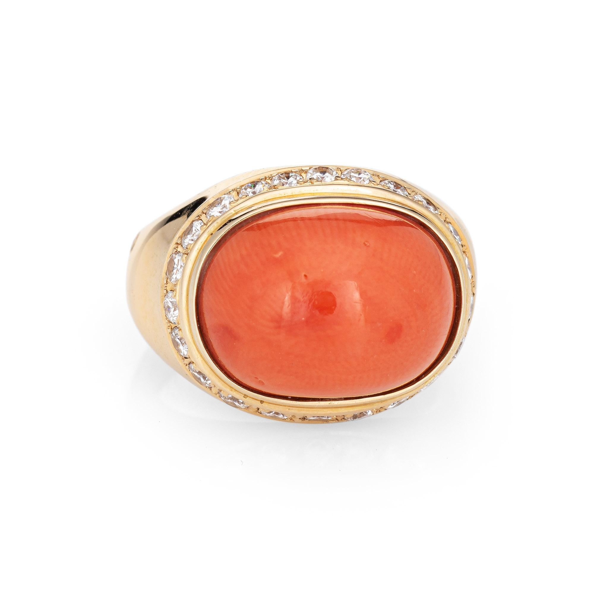 Stylish vintage coral & diamond cocktail ring crafted in 18 karat yellow gold. 

Coral cabochon measures 14mm x 10.5mm (estimated at 7.18 carats) is accented with an estimated 0.55 carats (estimated at G-H color and VS2-SI1 clarity). Note: few
