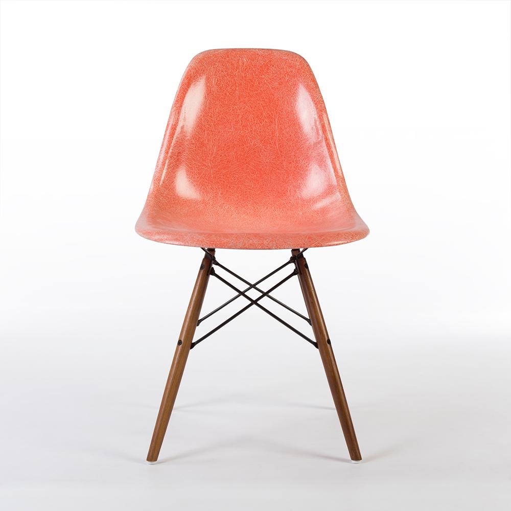 This is a used, Zenith faded salmon Herman Miller Eames dining chair, the shell has detailed fiberglass marks, attached to a natural oak wood dowel base to create a perfect dining chair. There are some scratches on the surface, and water marks are